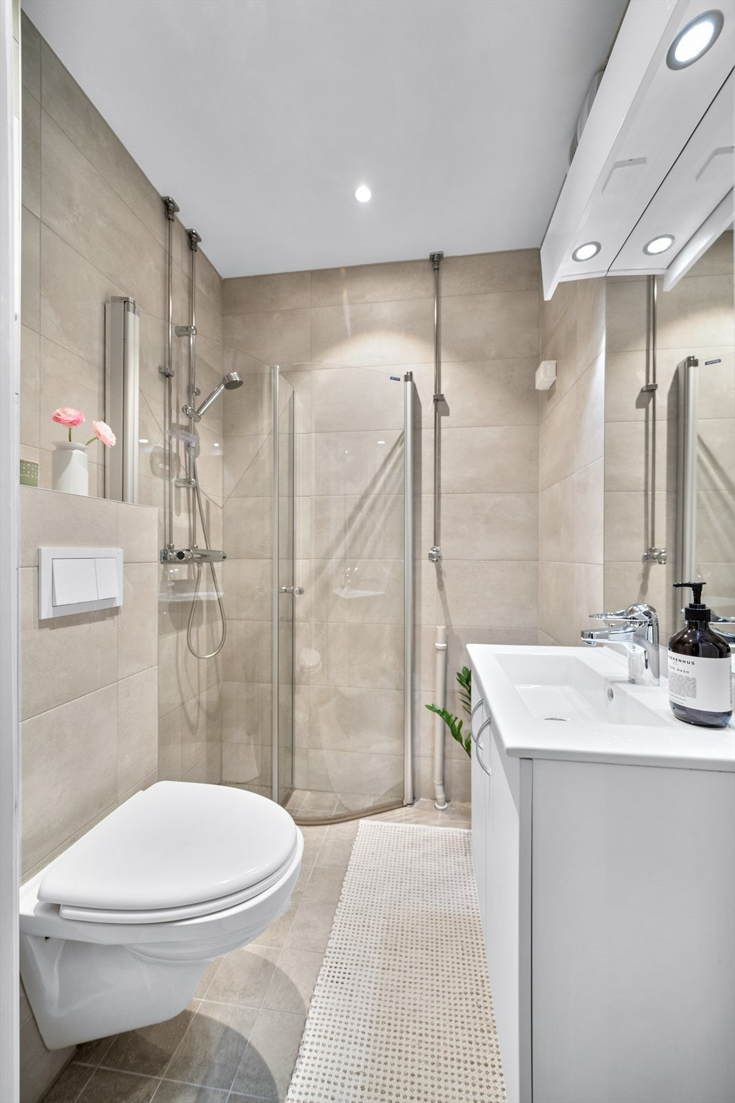 Badet er innredet med vegghengt toalett, servantinnredning, servant, dusjarmatur, plass og opplegg for vaskemaskin. Galleribilde