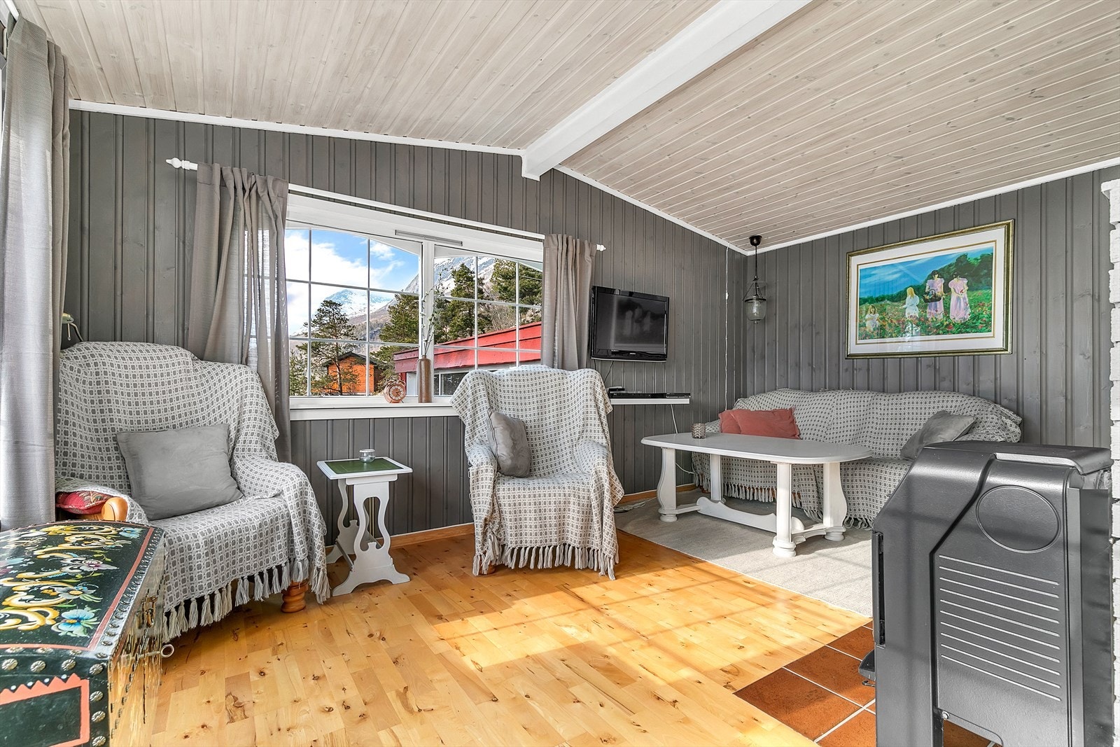 God plass for både sofa, stoler og mediemøblement i en sone av rommet. Stue er også utstyrt med vedovn. Galleribilde