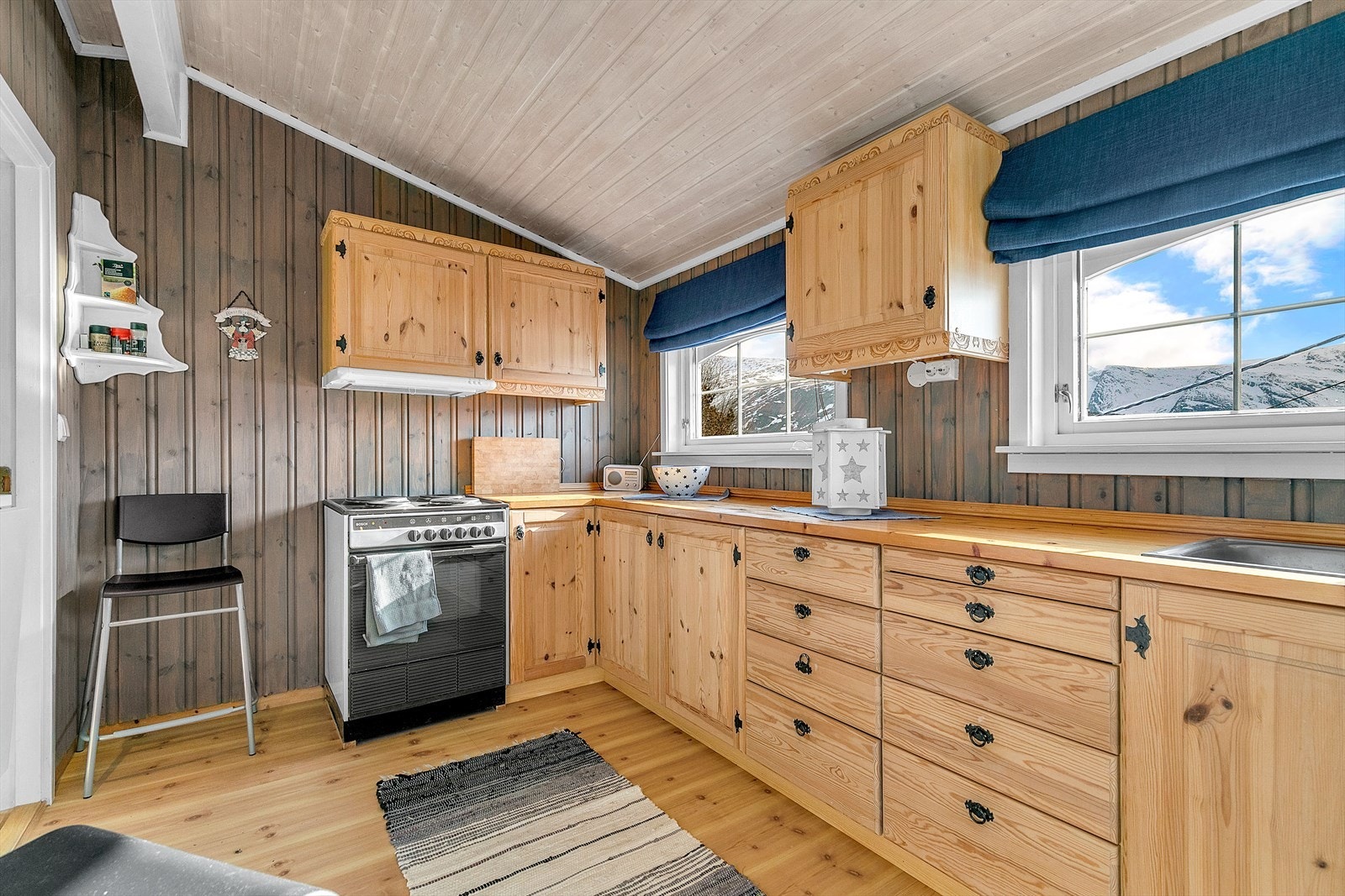 Koselig kjøkken med mye oppbevaringsplass i skuffer, skap og på benk. Galleribilde