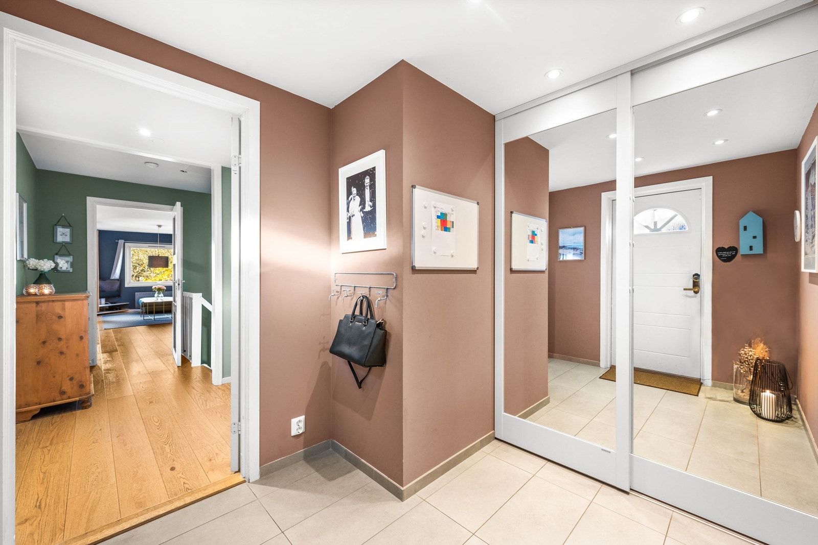 Stor og innbydende entre i første etasje som har godt med skapplass til å henge fra seg yttertøy og annet i skyvedørsgarderobe. Galleribilde