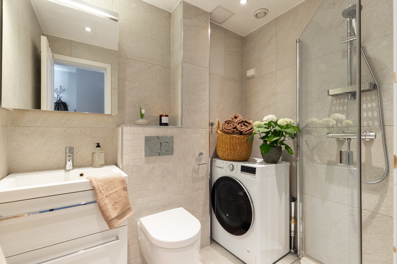 Boligens baderom er lyst, flislagt med varme i gulv og downlights i himling. Baderommet ble pusset opp i 2014. Galleribilde