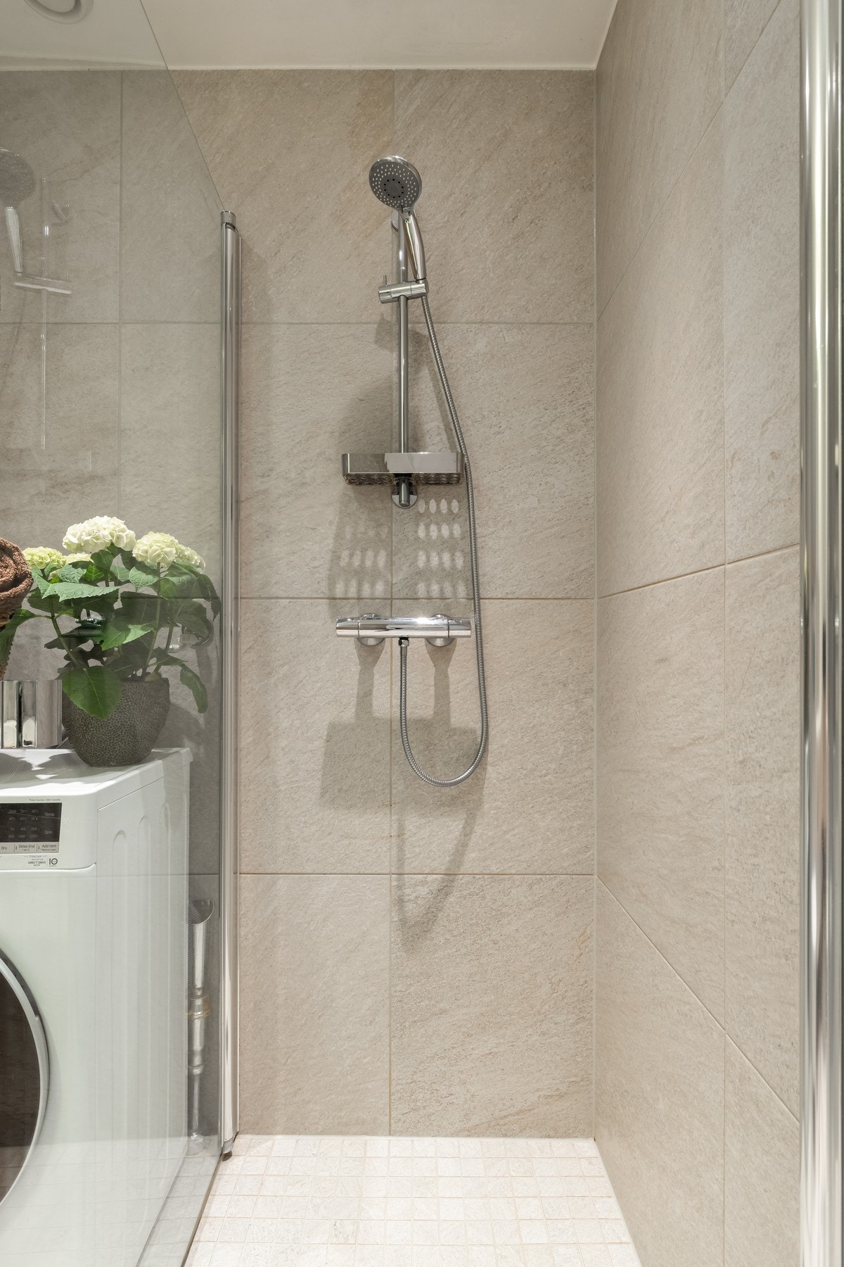 Videre er det dusjhjørne med svingbare glassdører som frigjør plass på gulvet. Galleribilde