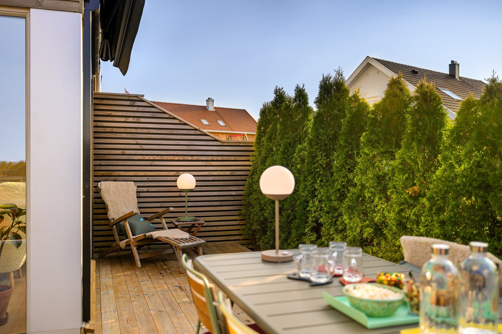 Når du sitter ute på terrassen ivaretas privatlivet av både høy spilevegg og tettvoksende hekk i front. Galleribilde