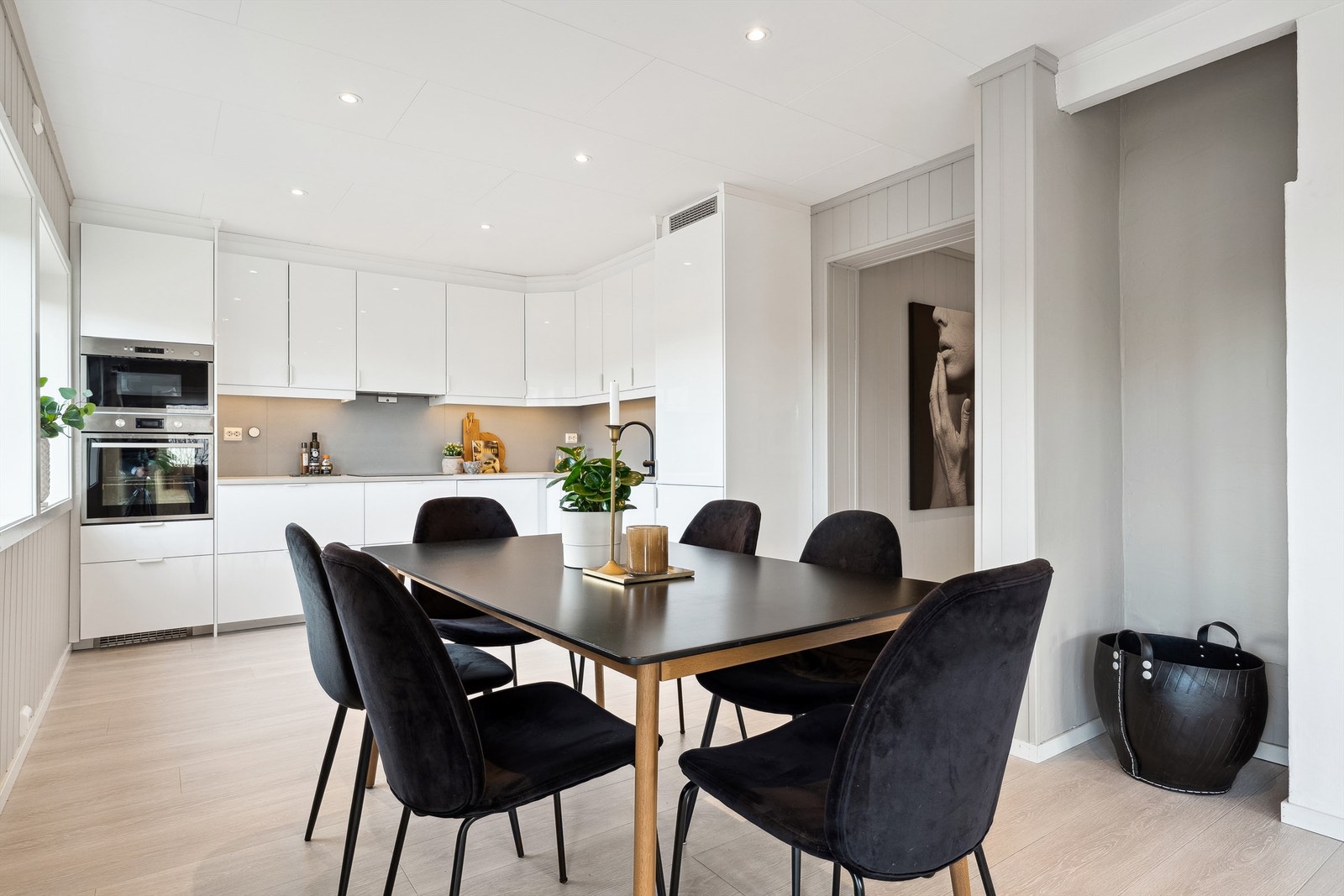 Kjøkkenet ligger i åpen løsning til spisestuen og har hvit, glatte fronter og benkeplate av laminat med nedfelt oppvaskkum. Galleribilde