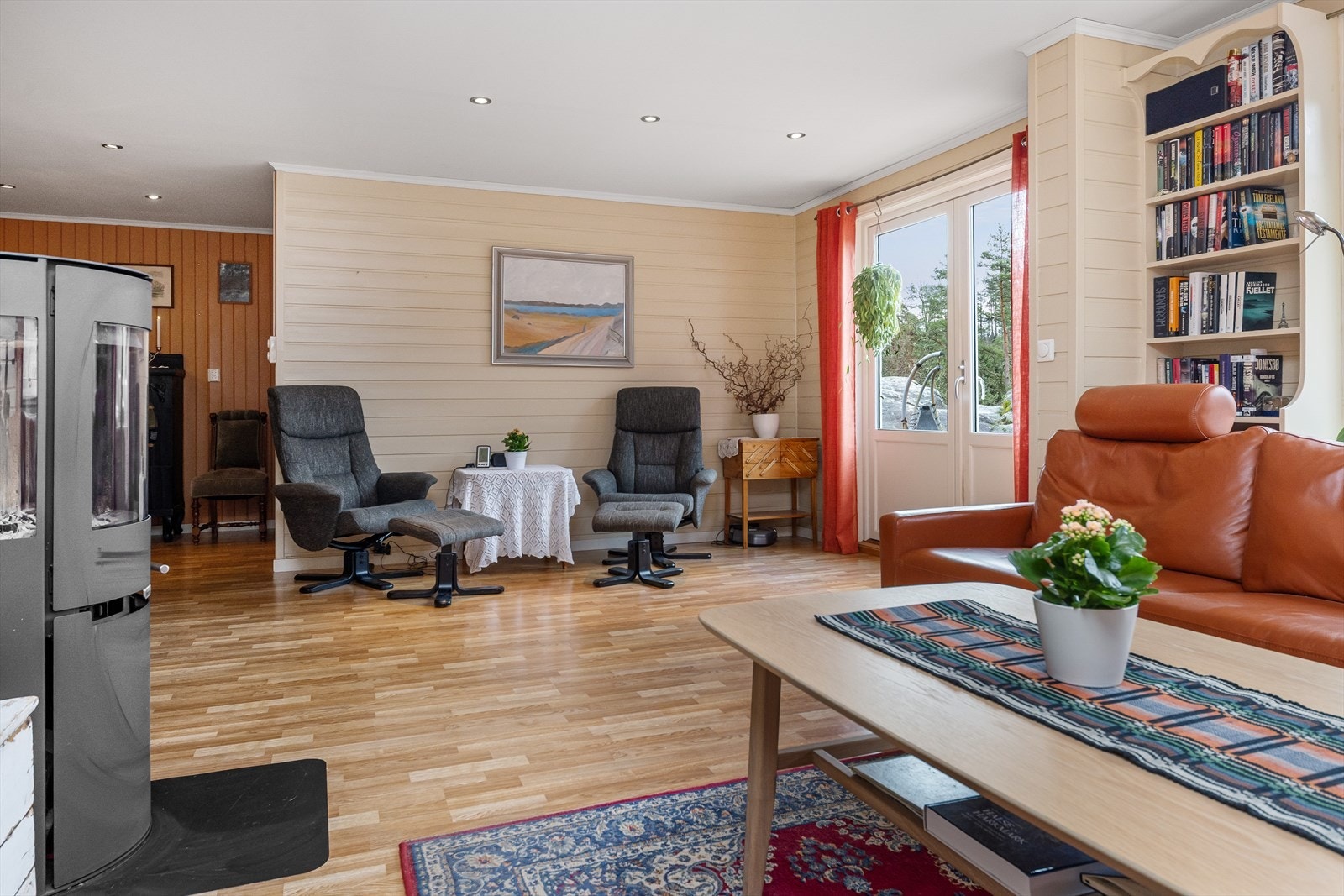 Stuen har store vinduer og dør ut til romslig terrasse med basseng. Galleribilde