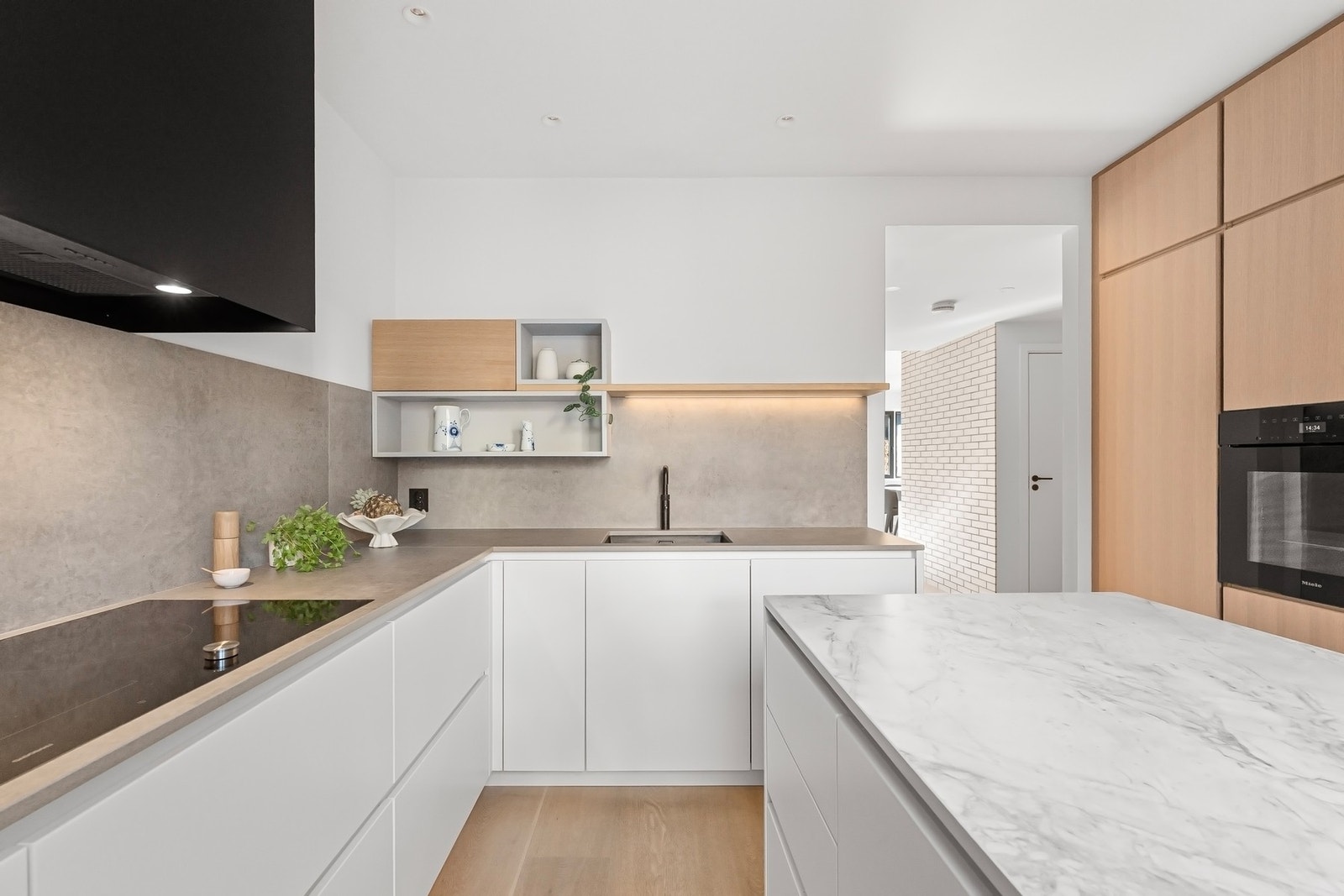 Kjøkkeninnredningen er delikat med glatte fronter, benkeplater i steinkompositt og rikelig med oppbevaringsplass. Galleribilde