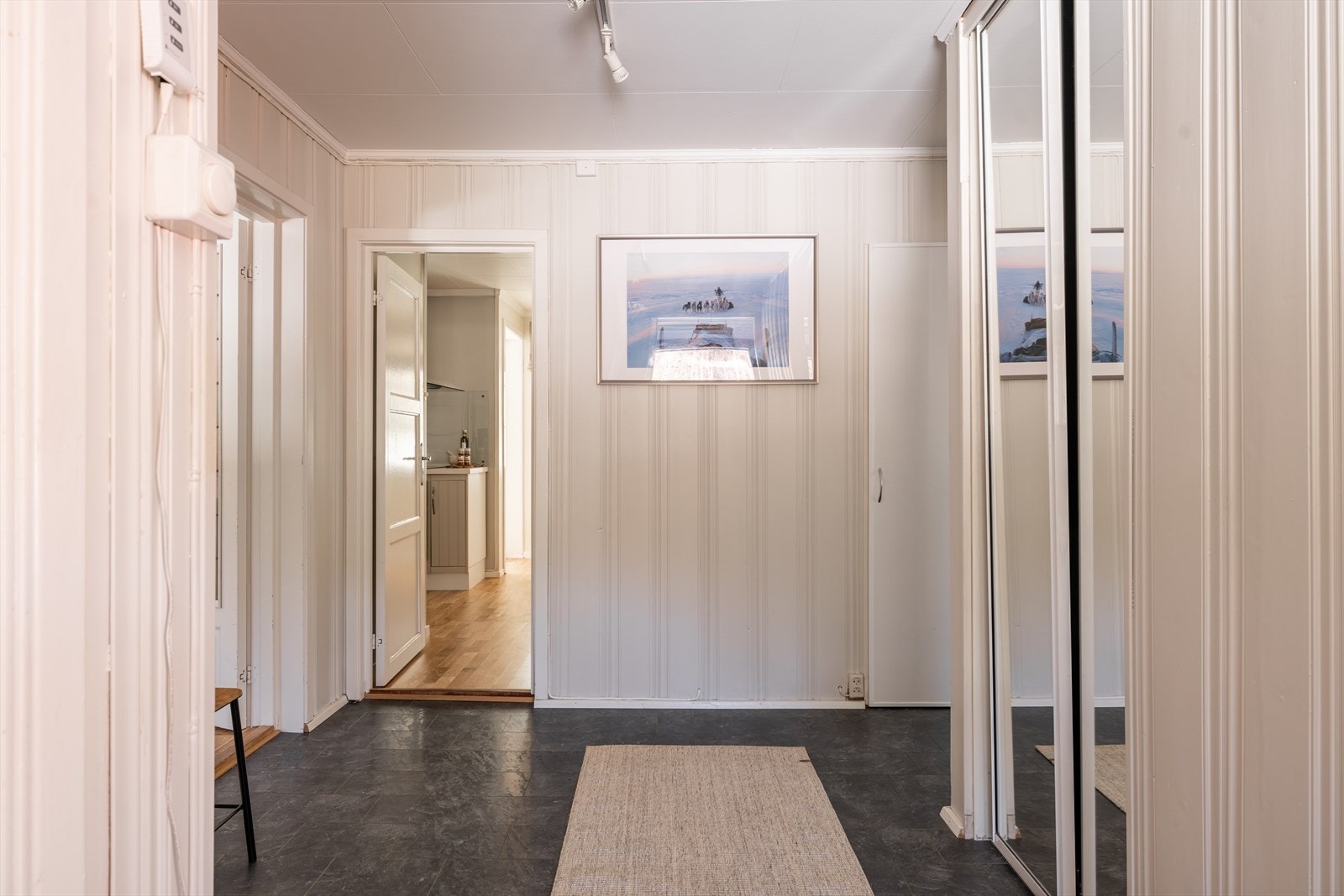 God plass til oppbevaring av sko og yttertøy i praktisk skyvedørsgarderobe med speilfronter, som gir et ryddig og stilrent uttrykk. Galleribilde