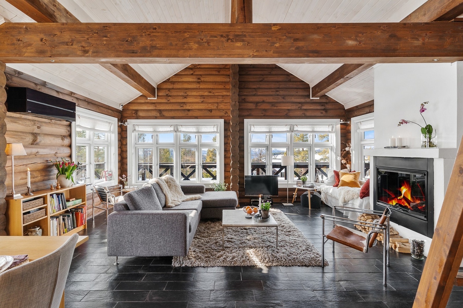 Lys og innbydende stue, med store vinduer, synlige dragere og god takhøyde. Galleribilde