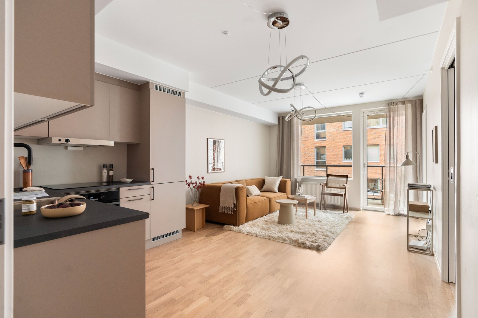 Åpen stue- og kjøkkenløsning som skaper en lys, luftig og sosial sone - perfekt for både hverdagsliv og sammenkomster Galleribilde