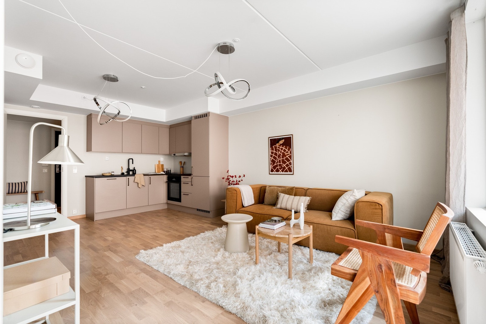 Med sin åpne løsning mot kjøkkenet gir denne stuen en sosial og funksjonell sone Galleribilde