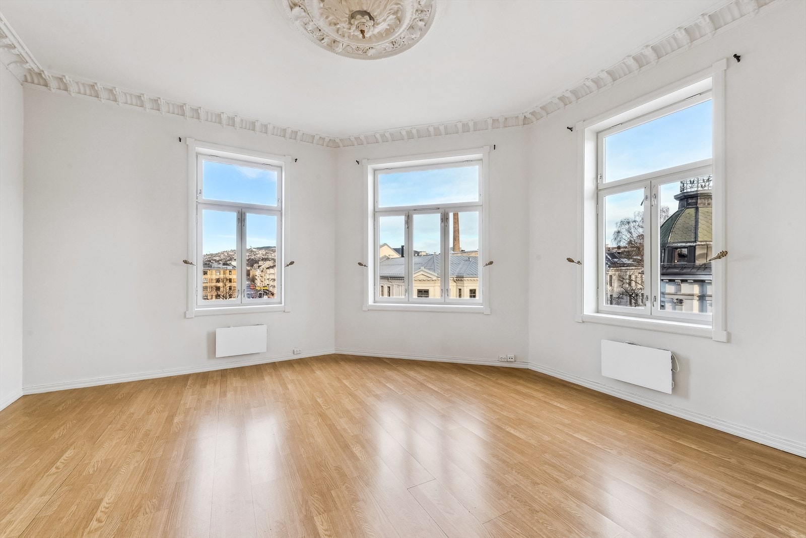 Stukkatur, rosett og god takhøyde samt store vinduer som skaper en lys og luftig atmosfære Galleribilde