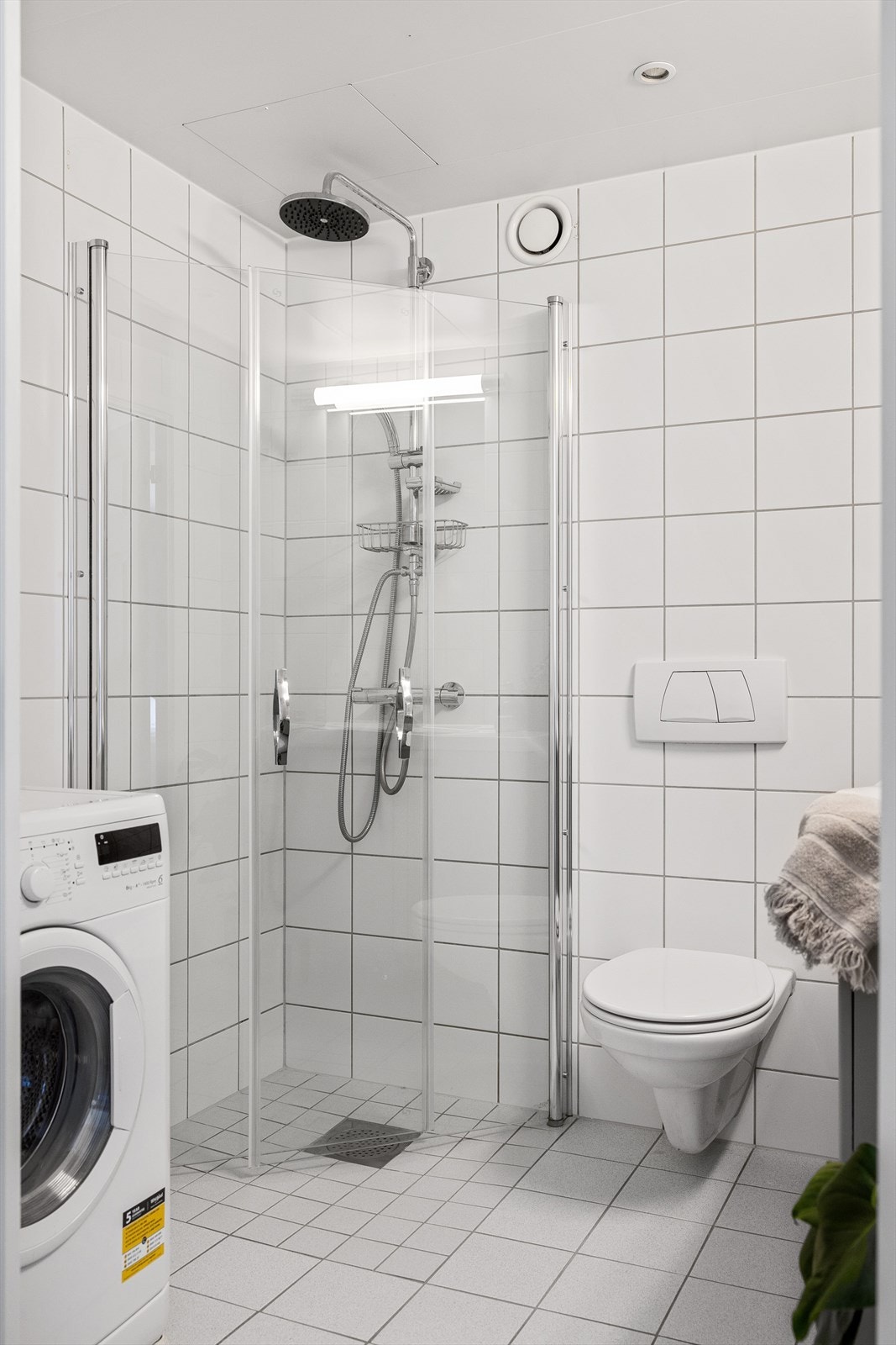 Badet er innredet med et praktisk servantskap og en ovenpåliggende servant, samt speil med overlys. Galleribilde