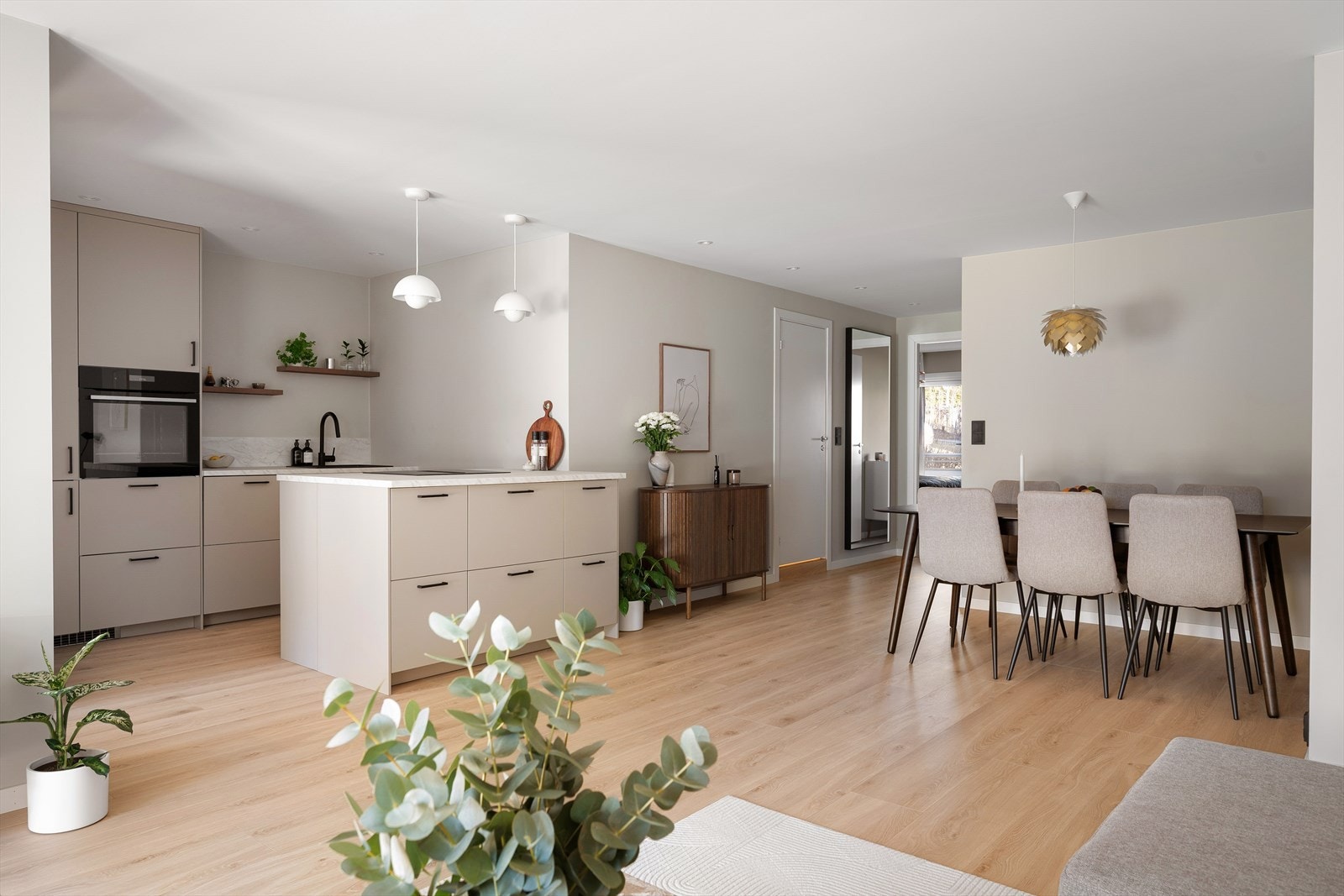 Stuen og kjøkkenet er gjort i en åpen løsning, men deles naturlig inn i to soner ved bruk av kjøkkenøy Galleribilde