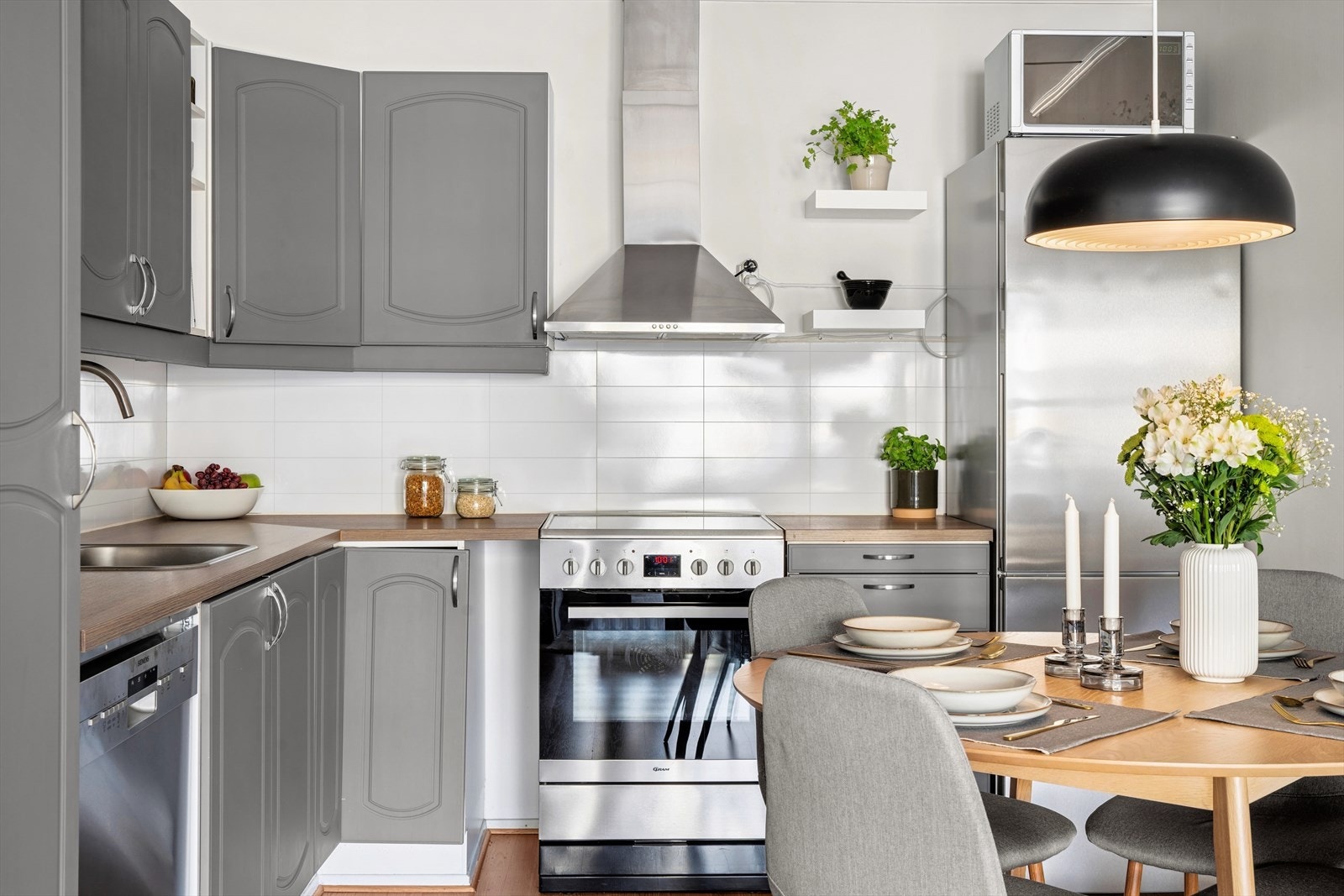 Plater og belysning over laminert benkeplate med nedfelt oppvaskkum. Galleribilde