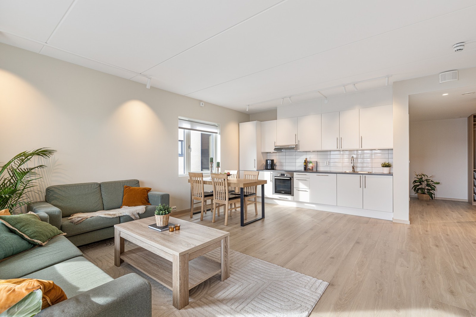 Kjøkkenet er laget i plassbesparende åpen løsning mot stuen som er med på å skape en sosial og åpen planløsning Galleribilde