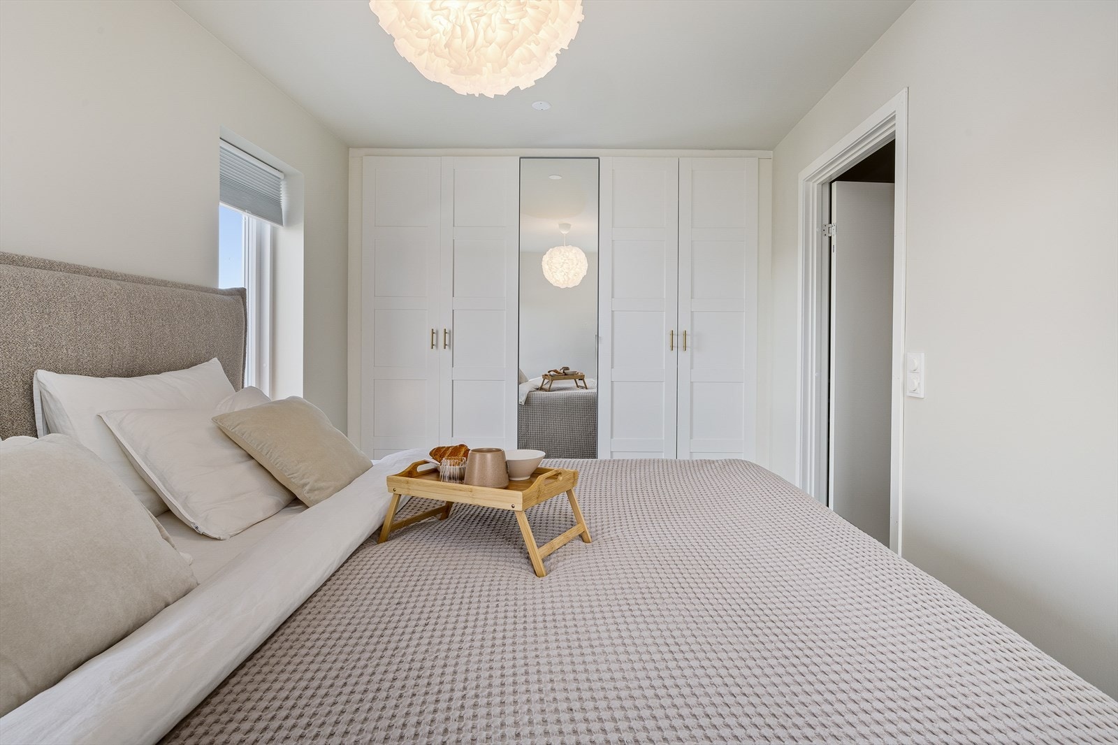 Det store garderobeskapet gir rikelig med oppbevaringsplass til klær og tilbehør, samtidig som det holder rommet ryddig og organisert. Galleribilde