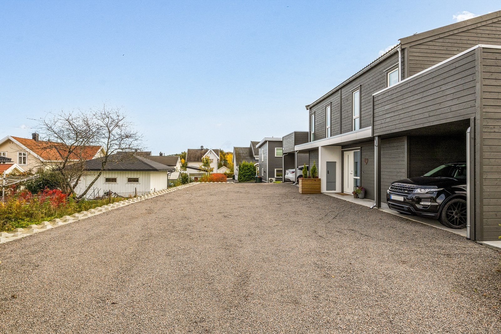 Carporten beskytter bilen mot vær og vind, samtidig som den gir enkel adkomst til boligen. Den private gårdsplassen gir ekstra parkeringsplass for både beboere og gjester, noe som gjør det enkelt å invitere venner og familie på besøk. Galleribilde