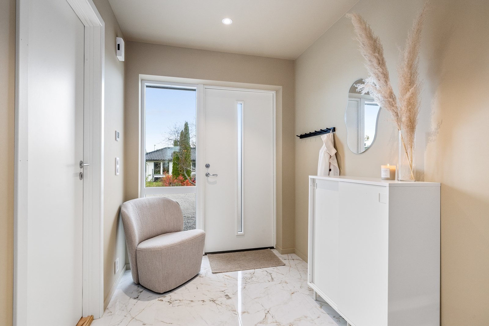 De lyse veggene og det stilige gulvet gir rommet et moderne uttrykk, samtidig som det føles luftig og romslig. Entréen setter tonen for resten av boligen og gir et godt førsteinntrykk når du kommer hjem eller tar imot gjester. Galleribilde