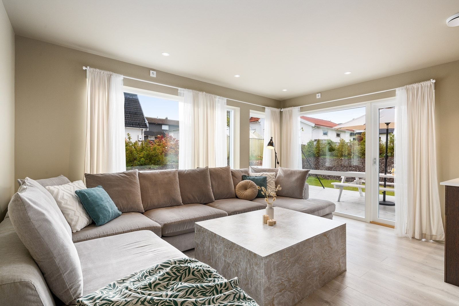 De store vindusflatene slipper inn rikelig med naturlig lys og gir rommet en luftig og åpen følelse. Fra stuen er det utgang til en solrik terrasse. Dette gjør overgangen mellom inne- og uterom sømløs, og gir mulighet for å trekke utendørs på fine dager. Galleribilde