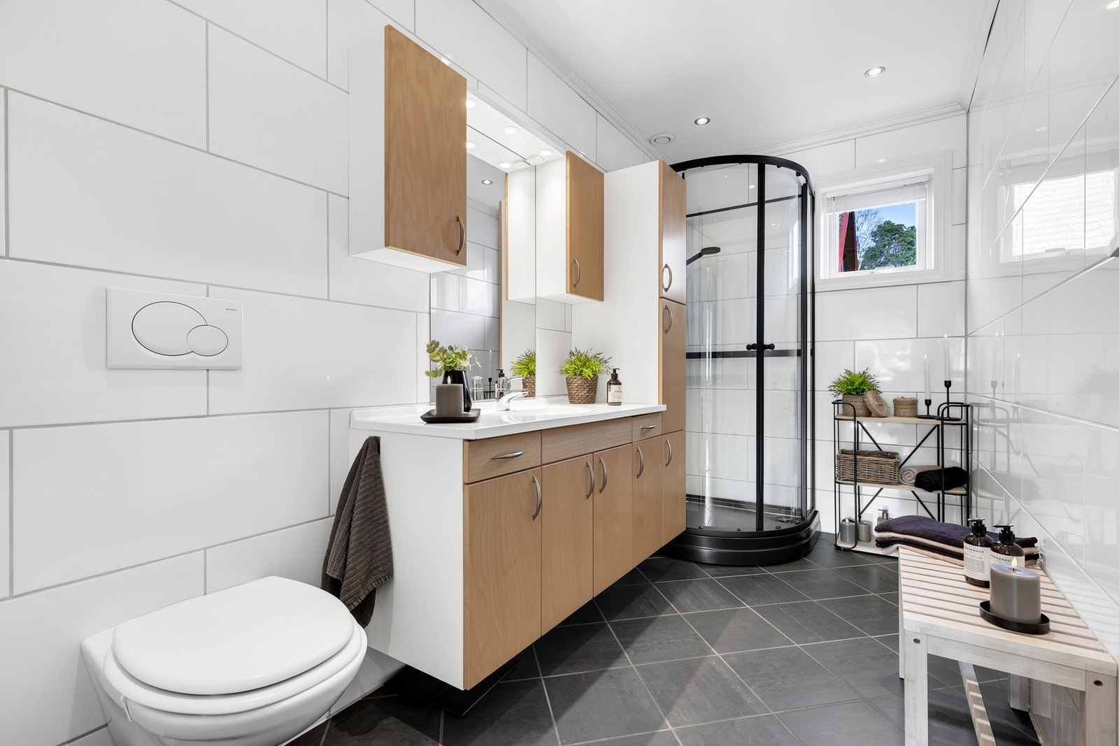 Badet er romslig med sine 5,5 kvm og har innredning med mye plass, vegghengt toalett og nytt dusjkabinett fra 2025. Galleribilde