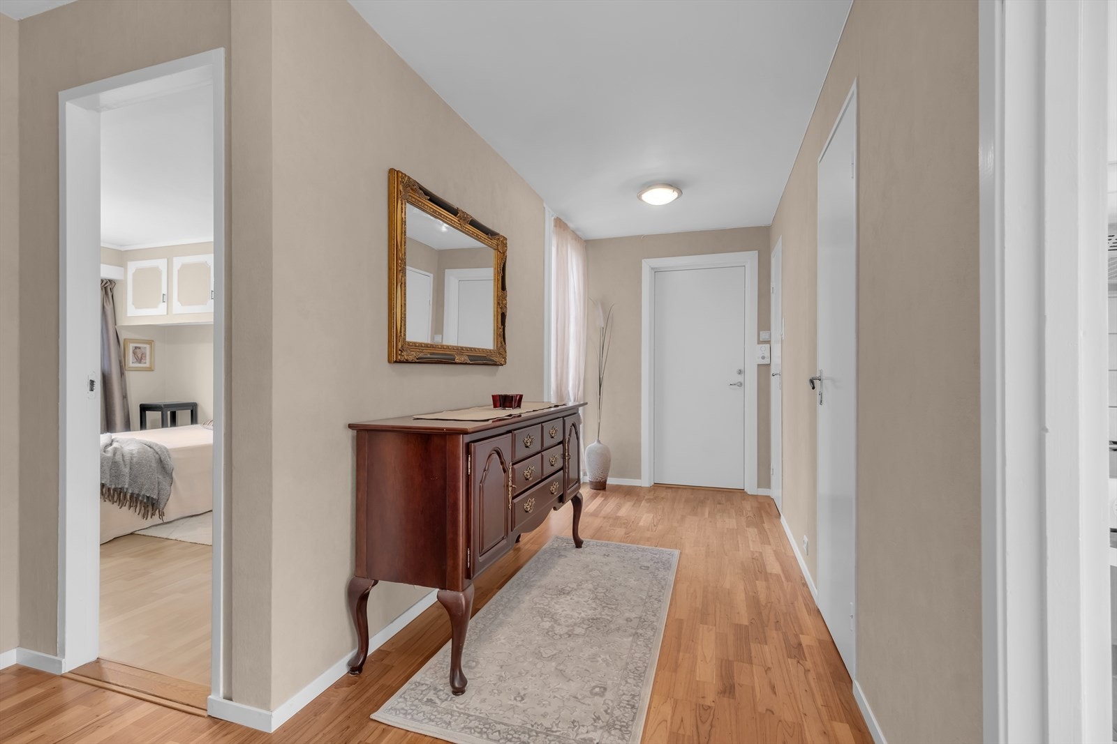 Flott gang med parkettgulv og lyse farger på veggene. Plass til møblement for oppheng av yttertøy og sko Galleribilde