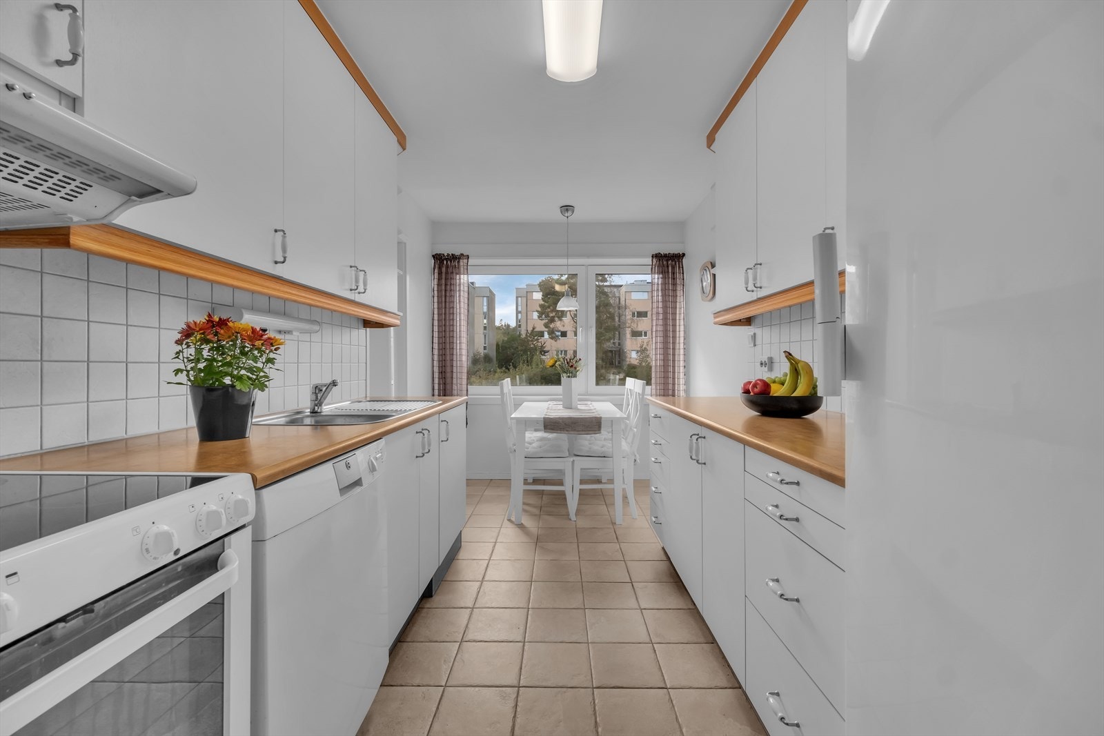 Flott kjøkken med fliser på gulv og lyse farger på veggene Galleribilde