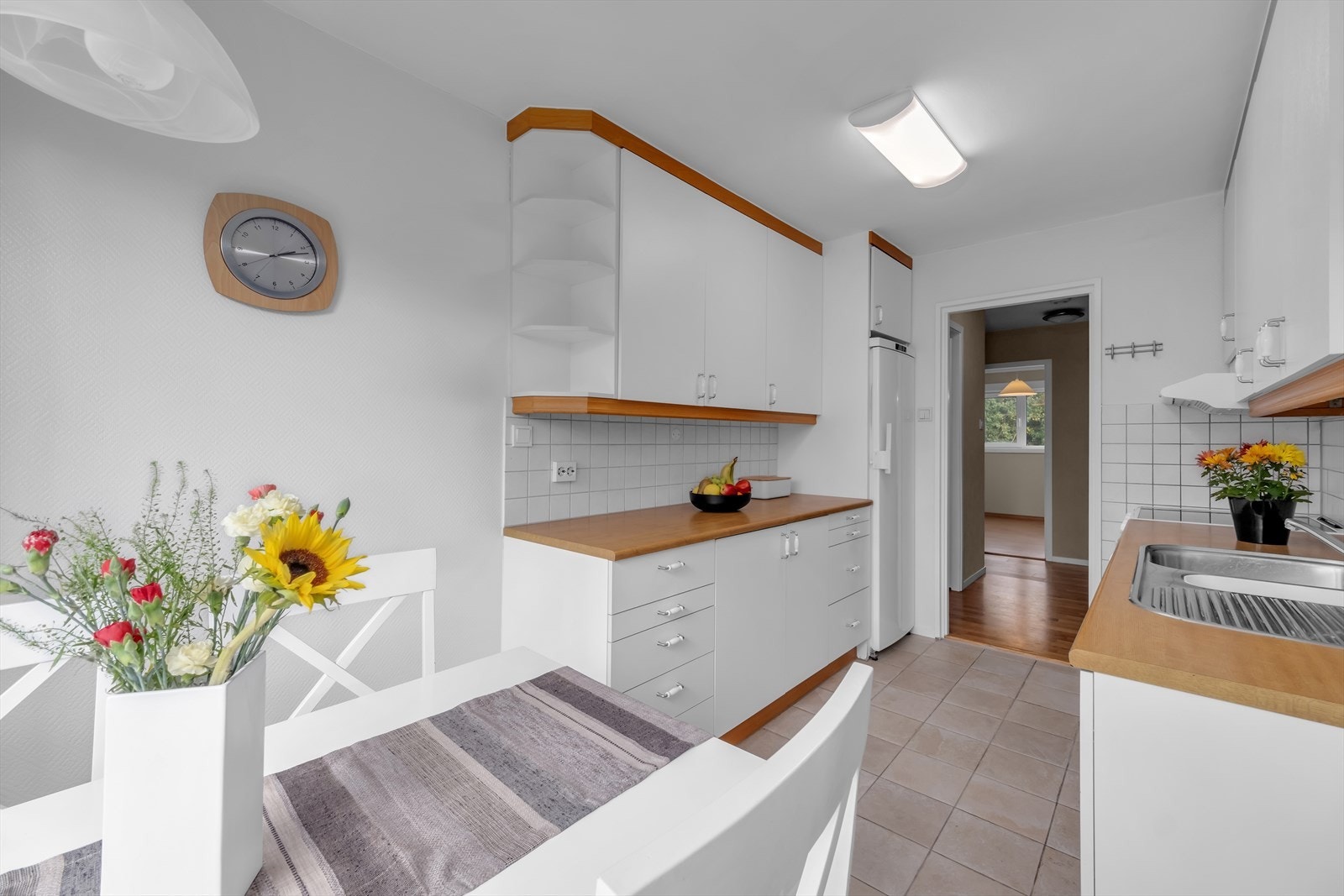 Kjøkkenet har glatte hvite fronter og benkeplate av laminat Galleribilde