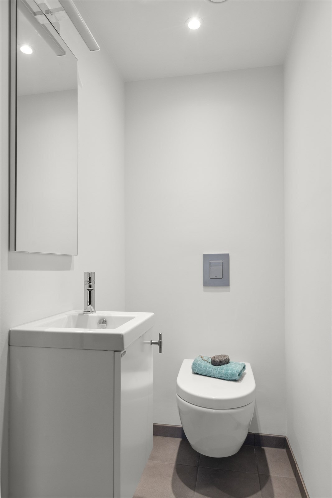 Toalettrommet har fliser på gulv og malte vegger, utstyrt med vegghengt toalett og baderomsinnredning med servant. Galleribilde