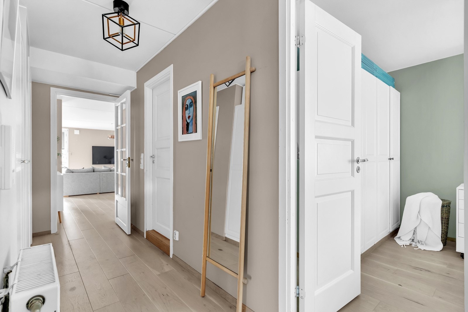 Entreen er lys og innbydende, med enstavs eikeparkett på gulvet, malte, slette vegger i en dus beigefarge og hvitmalt elementtak i betong. Galleribilde