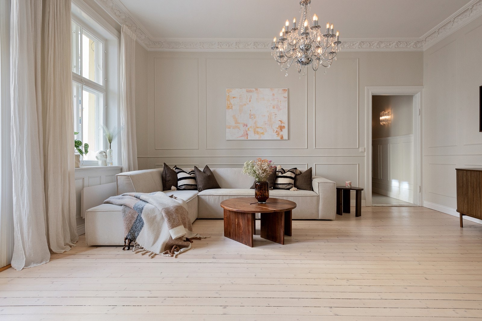 Stuen preges av klassiske detaljer som stukkatur og rosett, samt brystpanel på veggene, som tilfører rommet et tidløst og elegant uttrykk Galleribilde