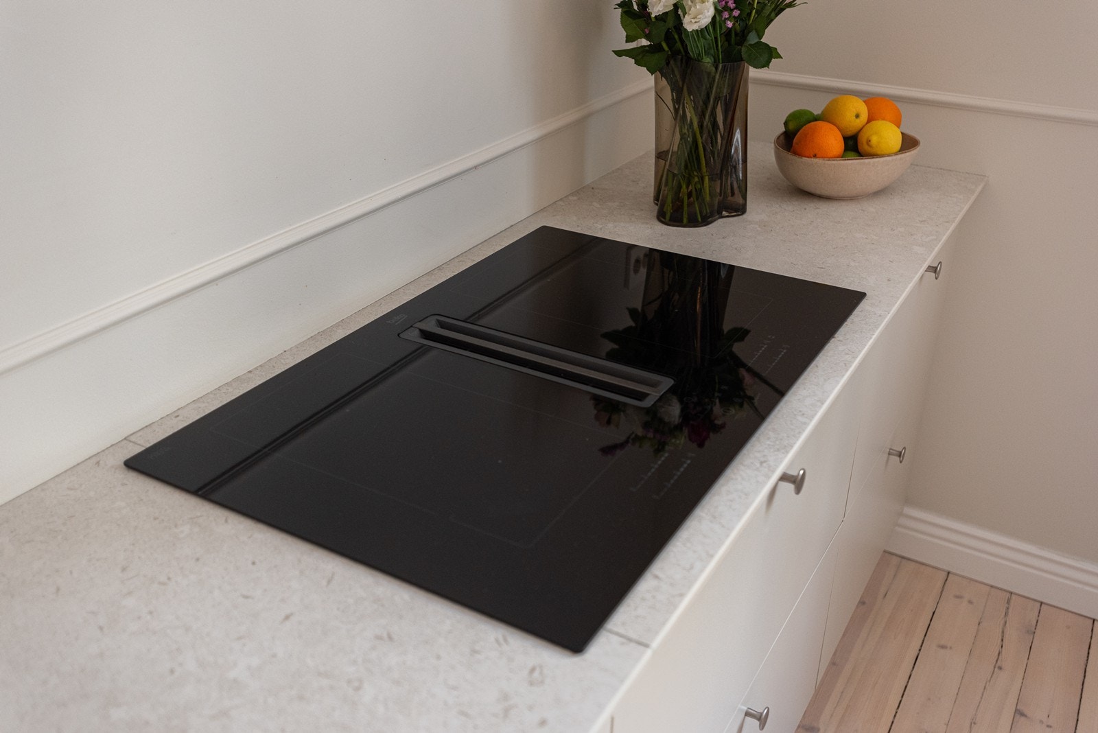 Kjøkkenet har smarte løsninger som kokeplate med innebygd kjøkkenvifte Galleribilde