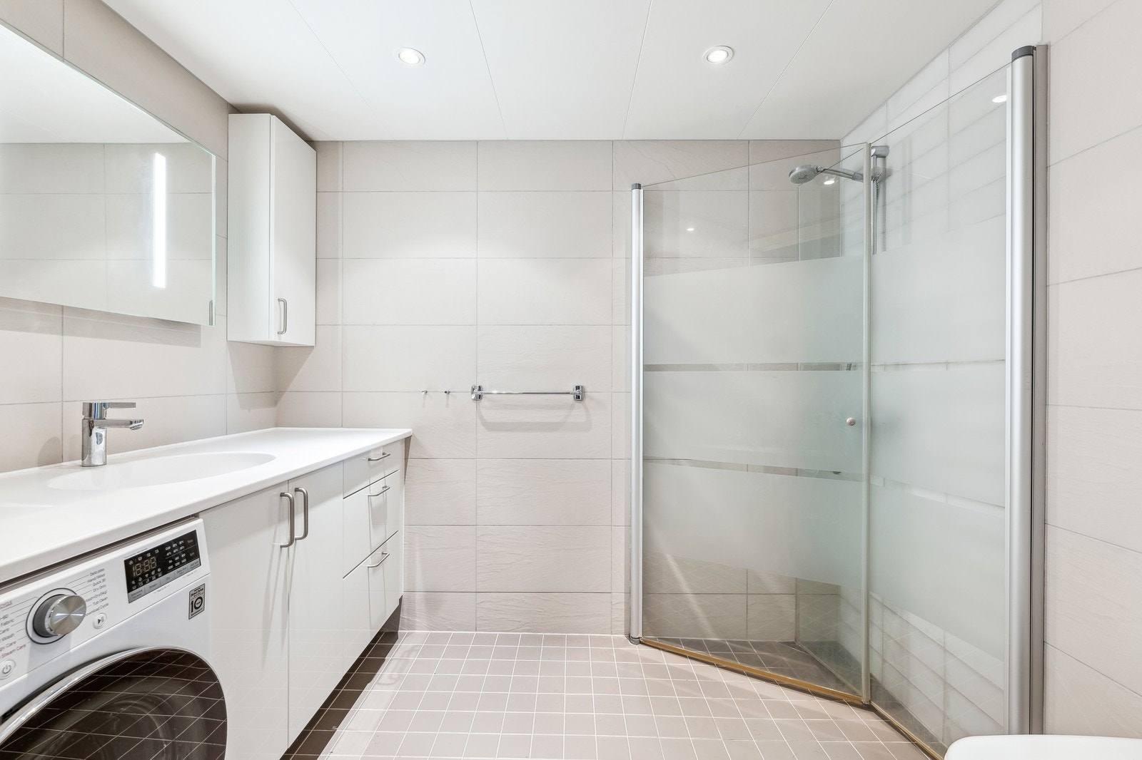 Morderne flislagt bad med kombindert vaskemaskin og tørketrommel inkludert Galleribilde