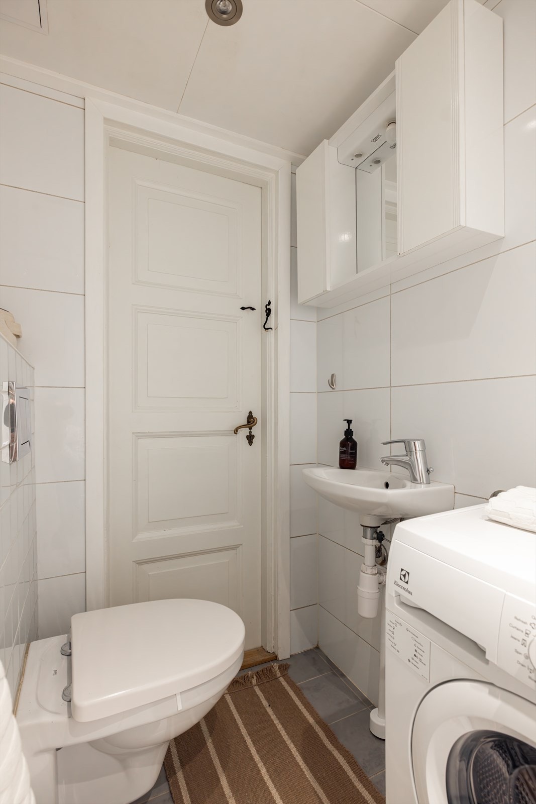 På badet er det servant med overskap, veggmontert toalett og dusjhjørne. Det er opplegg for vaskemaskin. Galleribilde