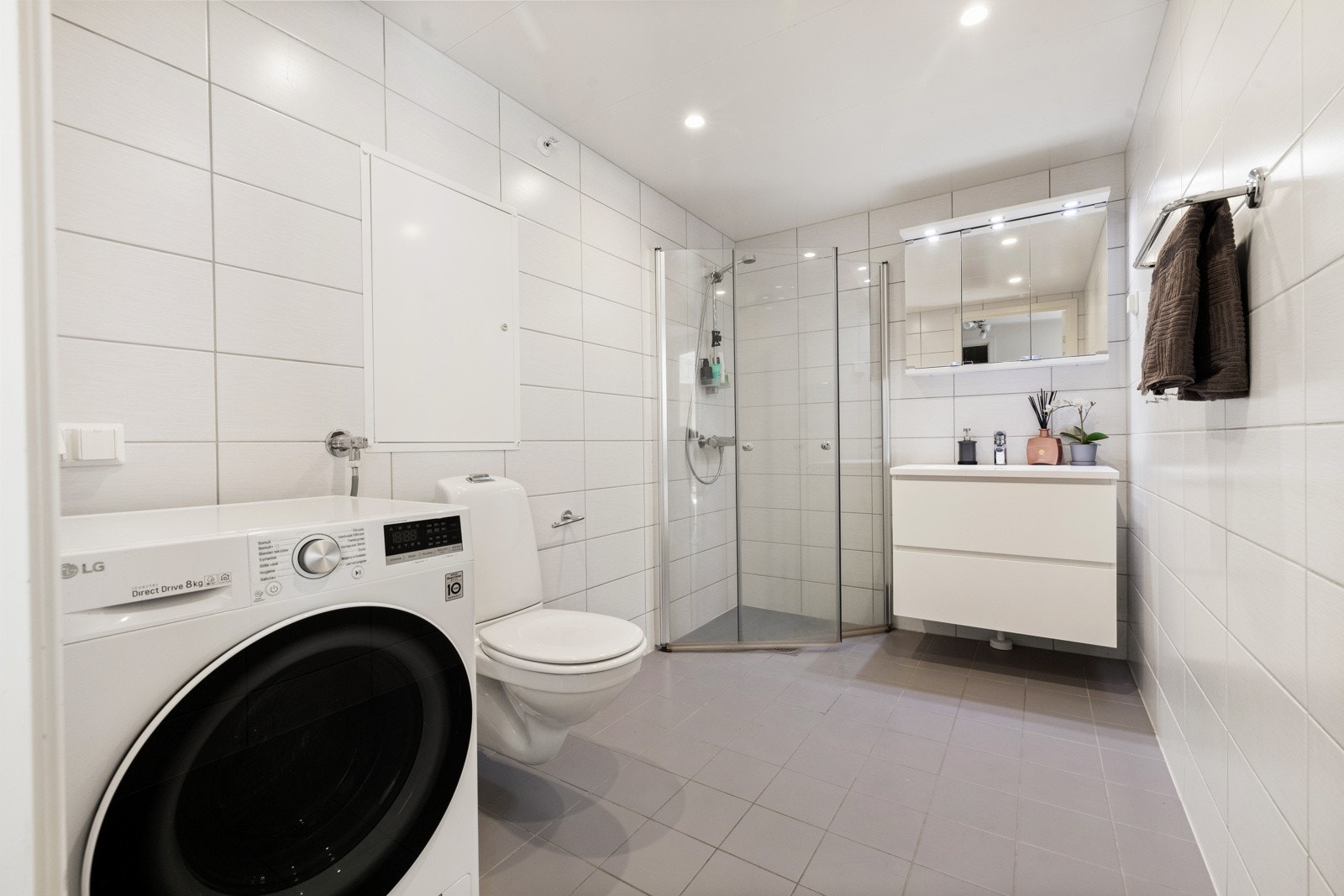 Pent baderom med flislagte overflater, varme i gulvet og downlightsbelysning. Galleribilde