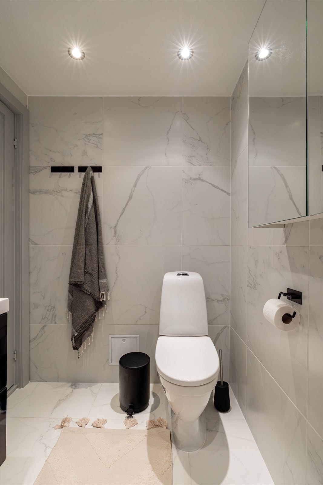 Et stilrent toalett med moderne, hvite fliser som gir rommet et friskt og rent preg. Galleribilde