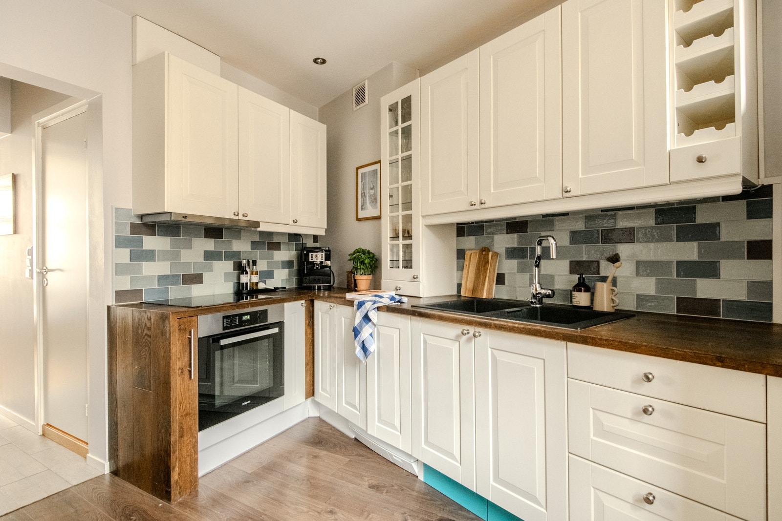 Kjøkkenet er godt planlagt med praktiske løsninger som blant annet sokkelskuffer, og har rikelig med skap- og benkeplass. Mellom benkeplaten og overskapene er det lagt fliser, som både er praktisk og gir et helhetlig inntrykk. Galleribilde