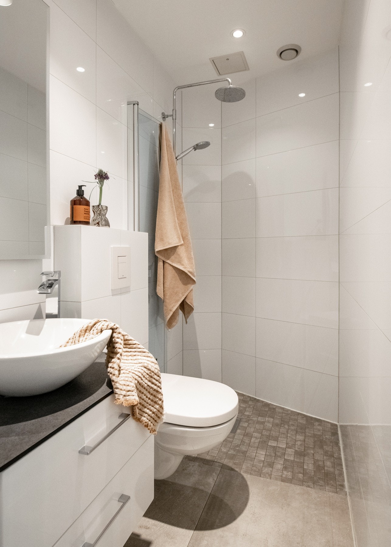 Innredningen består av en baderomsinnredning med to skuffer og en toppmontert servant, samt et speil plassert over servanten. Dusjhjørnet har foldedør i herdet glass og er utstyrt med en behagelig regnfallsdusj. Galleribilde