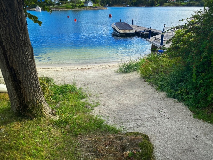 Tomt på rundt 2,3 mål med egen badestrand, dypvannsbrygge og flotte hageområder, kan denne eiendommen sies å være en perle av de sjeldne. Galleribilde