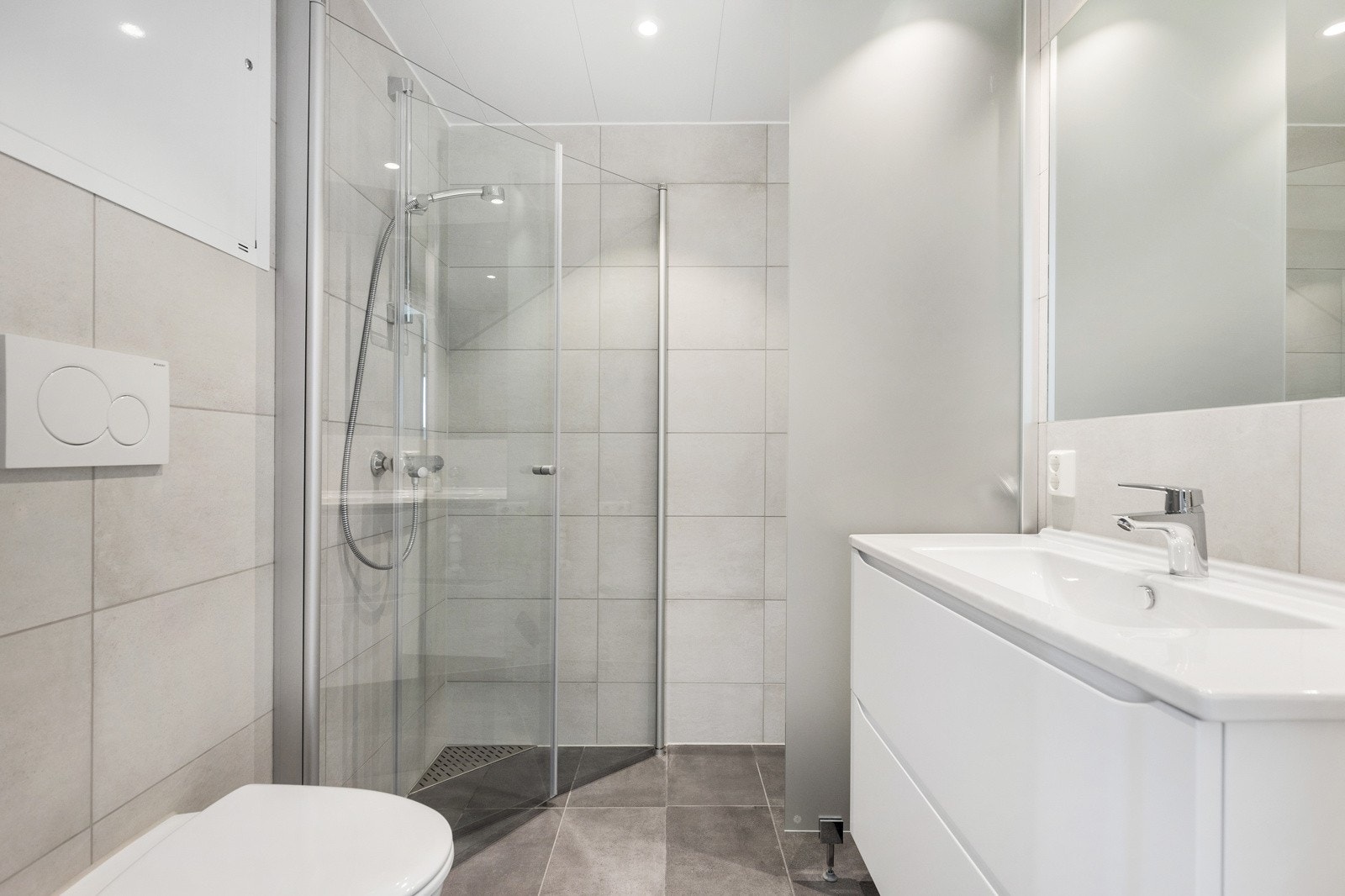 Flislagt bad med gulvvarme med moderne fliser og innredning Galleribilde