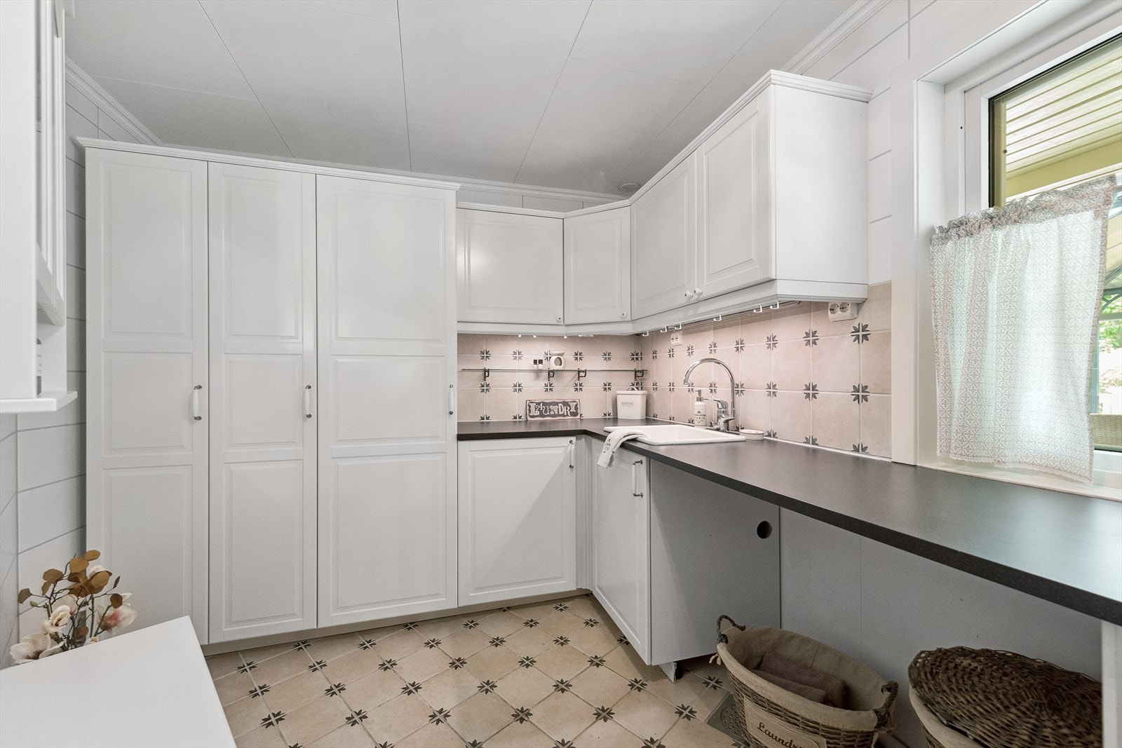 Vaskerommet har overflater på gulv med fliser og varmekabler, vegger med fliser og innvendige tak med ruteplater. Galleribilde