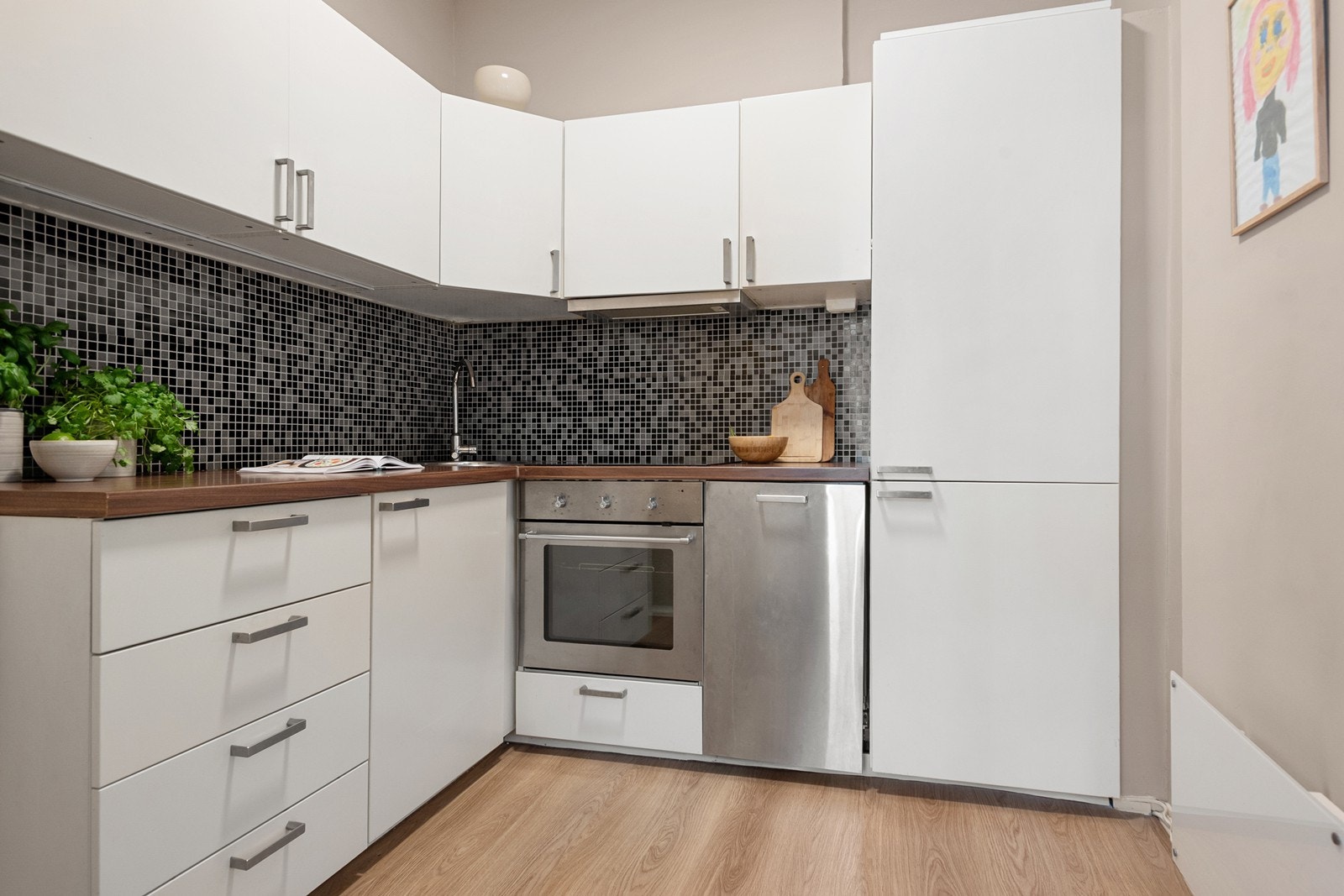 Kjøkkenet er utstyrt med kullfiltervifte over stekesonen, opplegg for oppvaskmaskin, integrerte hvitevarer som kjøl-/fryseskap, platetopp og stekeovn Galleribilde