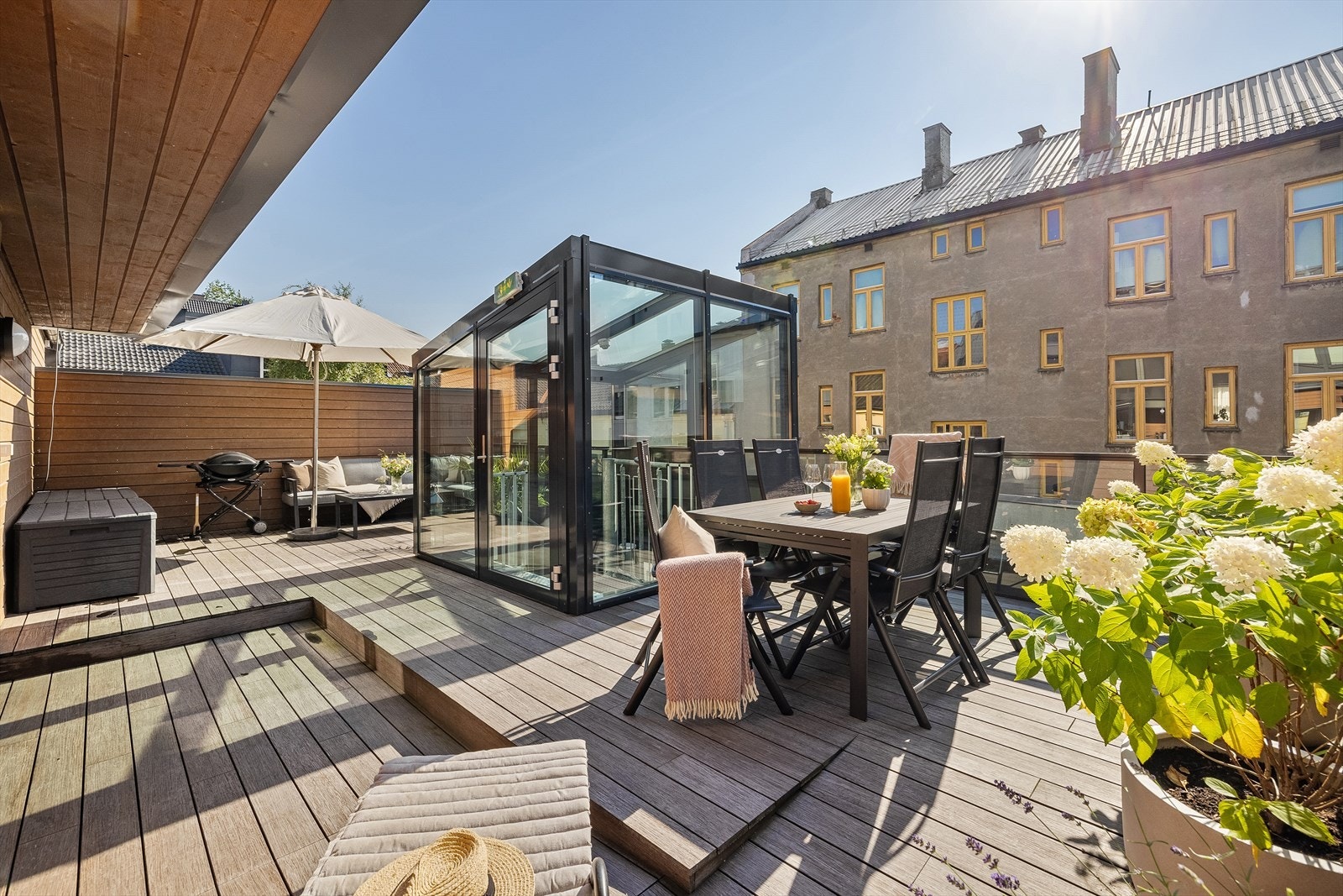 Stor, solrik felles takterrasse med utemøblement og grill Galleribilde