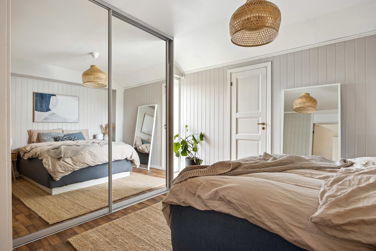 Det største loftsrommet er på 9m² og innredet som et koselig soverom med plass til en stor garderobe. Leilighetens endebeliggenhet byr på en bod bak den hvite døren. Galleribilde