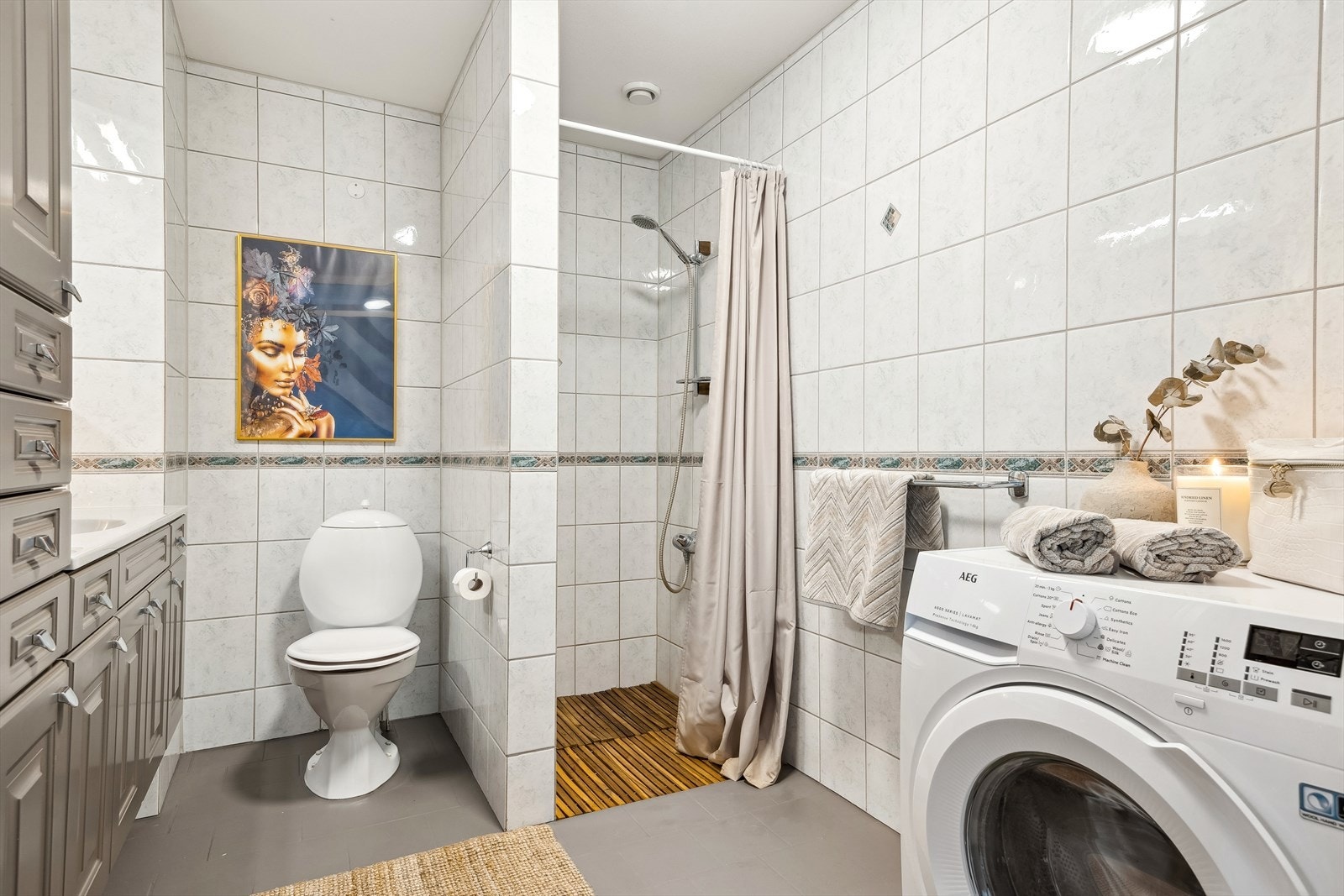 Rommet er innredet med servant med skuffer og god skapplass, speilskap, toalett og dusjhjørne. Det er også opplegg for vaskemaskin. Galleribilde