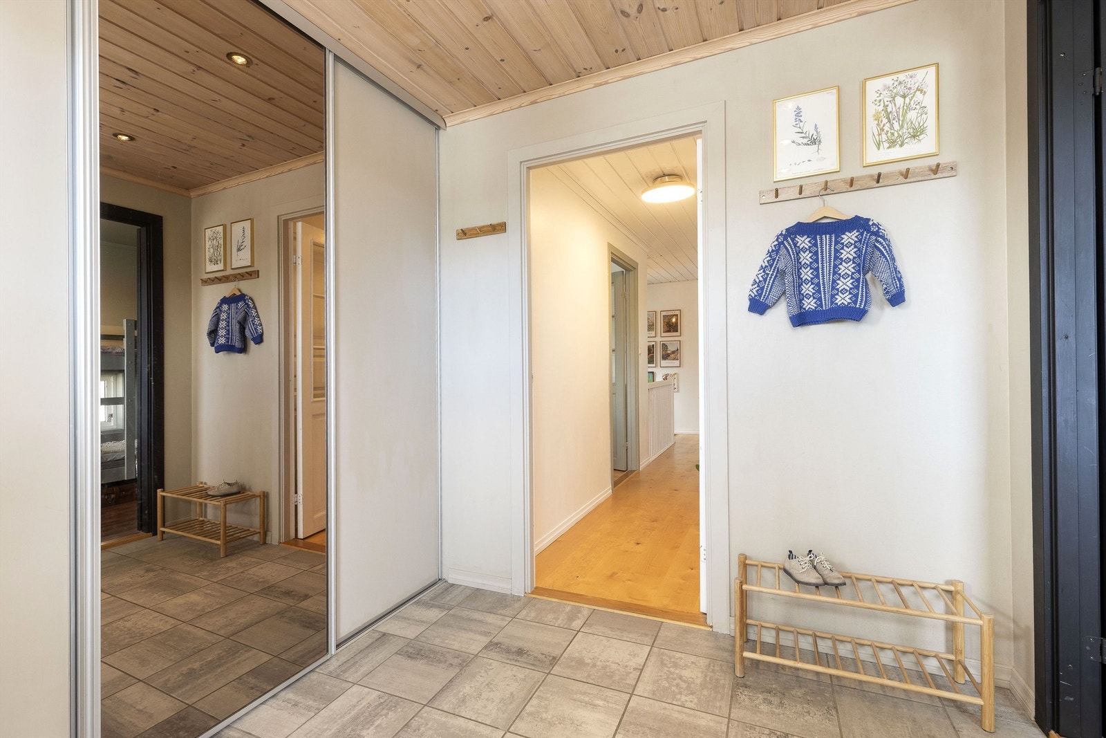 Romslig entré med skyvedørsgarderobe og varmekabler på flislagt gulv Galleribilde