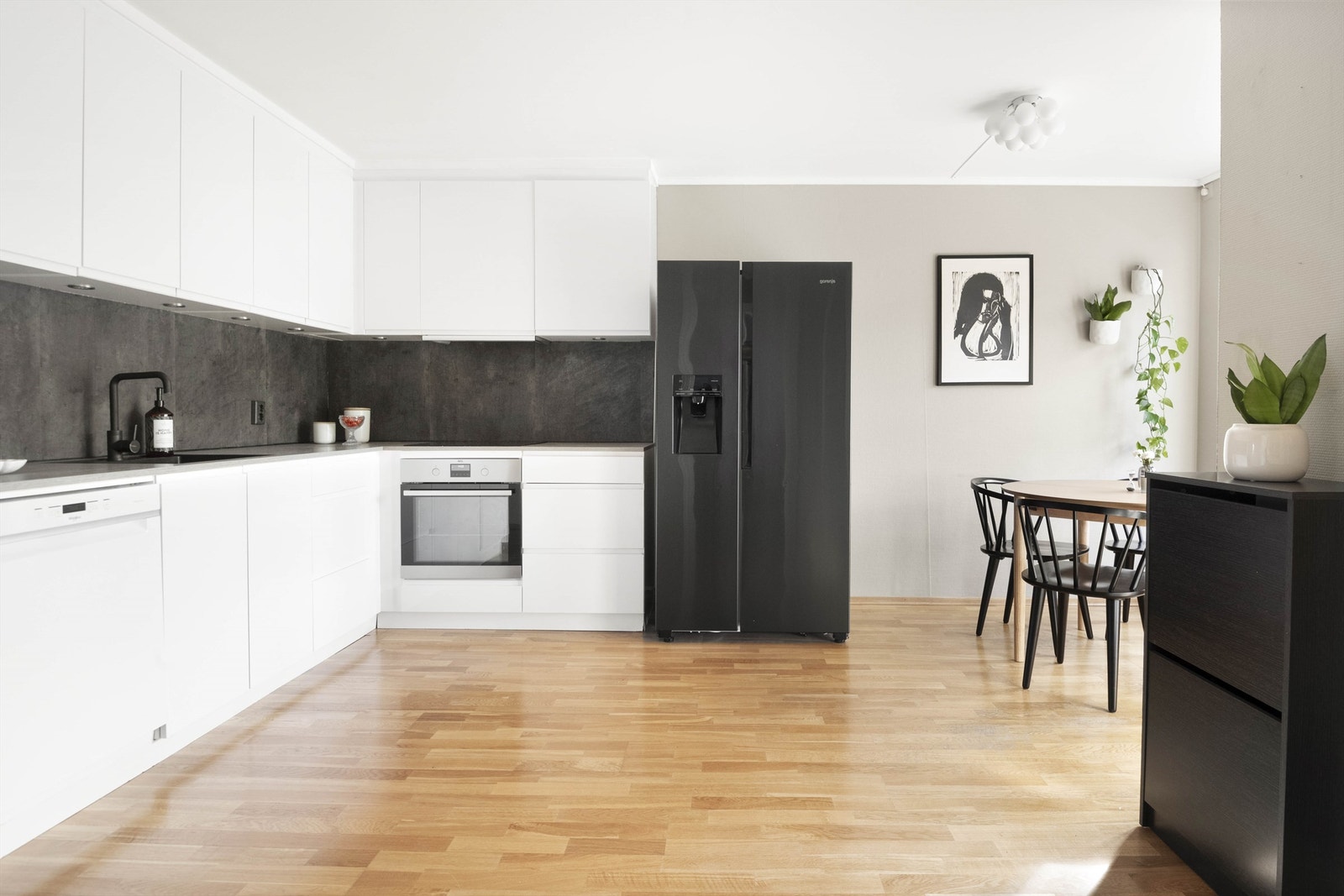 I delvis åpen løsning mot stuen har vi et stilrent kjøkken Galleribilde