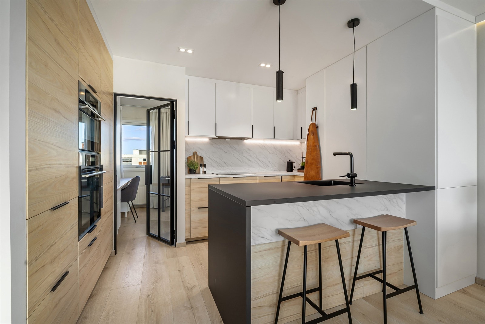 Kjøkkenet har glatte fronter med laminat benkeplate, planlimt oppvaskkum av kompositt med ett-greps blandebatteri, kullfilterventilator og integrert stikkontakt i benk. Galleribilde