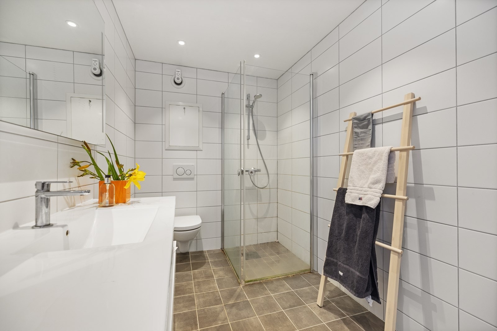 Flislagt bad/wc fra 2017 (nyere hybel). Badet er innredet med servant med underskap, vegghengt toalett og dusjhjørne/dører i glass. Det er opplegg for vaskemaskin Galleribilde