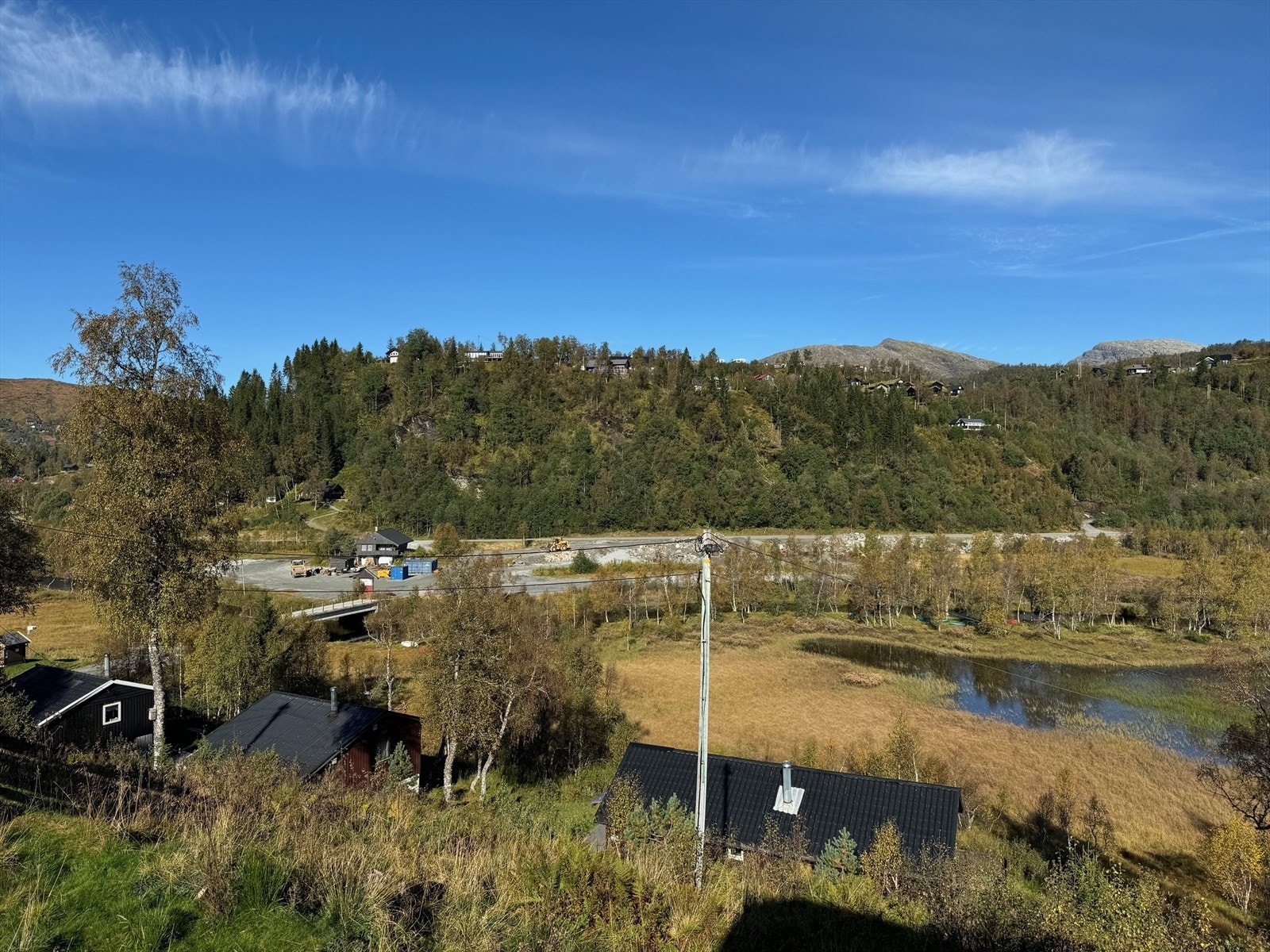 Utsikt fra eiendommen ned til parkeringsplass. Galleribilde