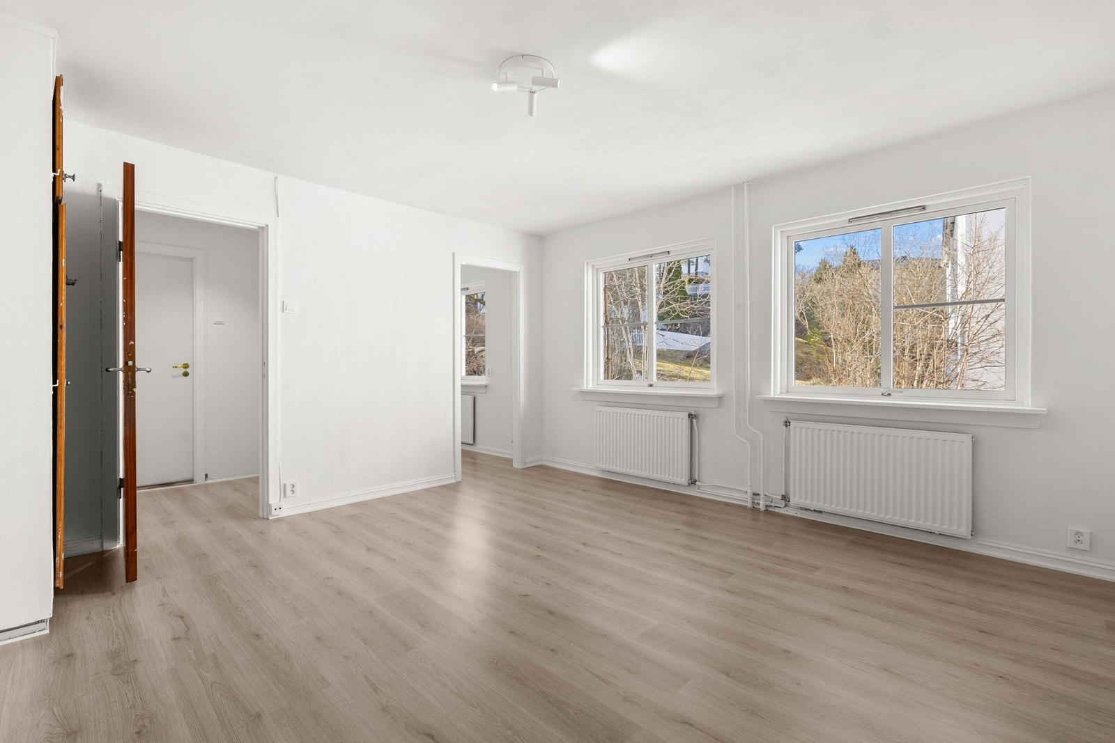 Romslige stue/spisestue med store vindusflater mot bakgård Galleribilde